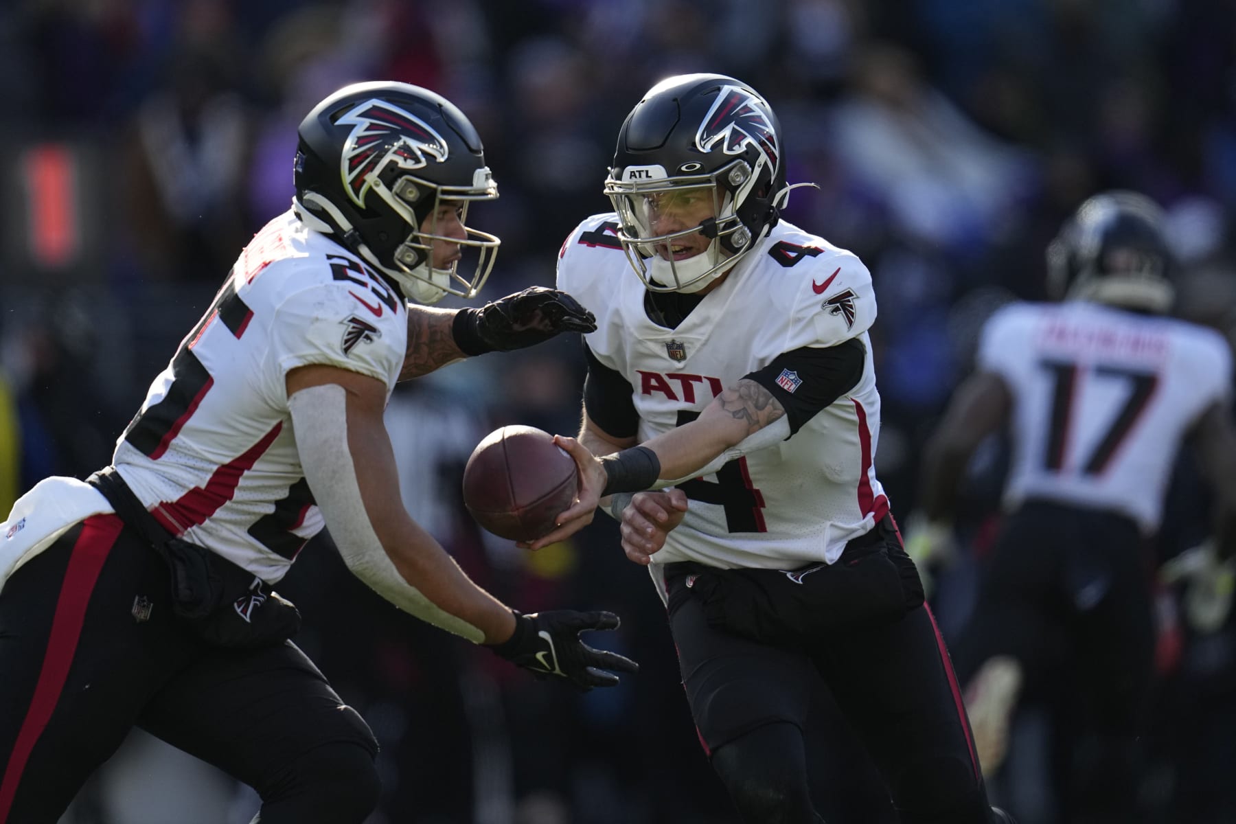Atlanta Falcons quarterback Desmond Ridder (4) hands off to running back Tyler Allgeier (25) during the first half of an NFL football game against the Baltimore Ravens, Saturday, Dec. 24, 2022, in Baltimore. (AP Photo/Julio Cortez)