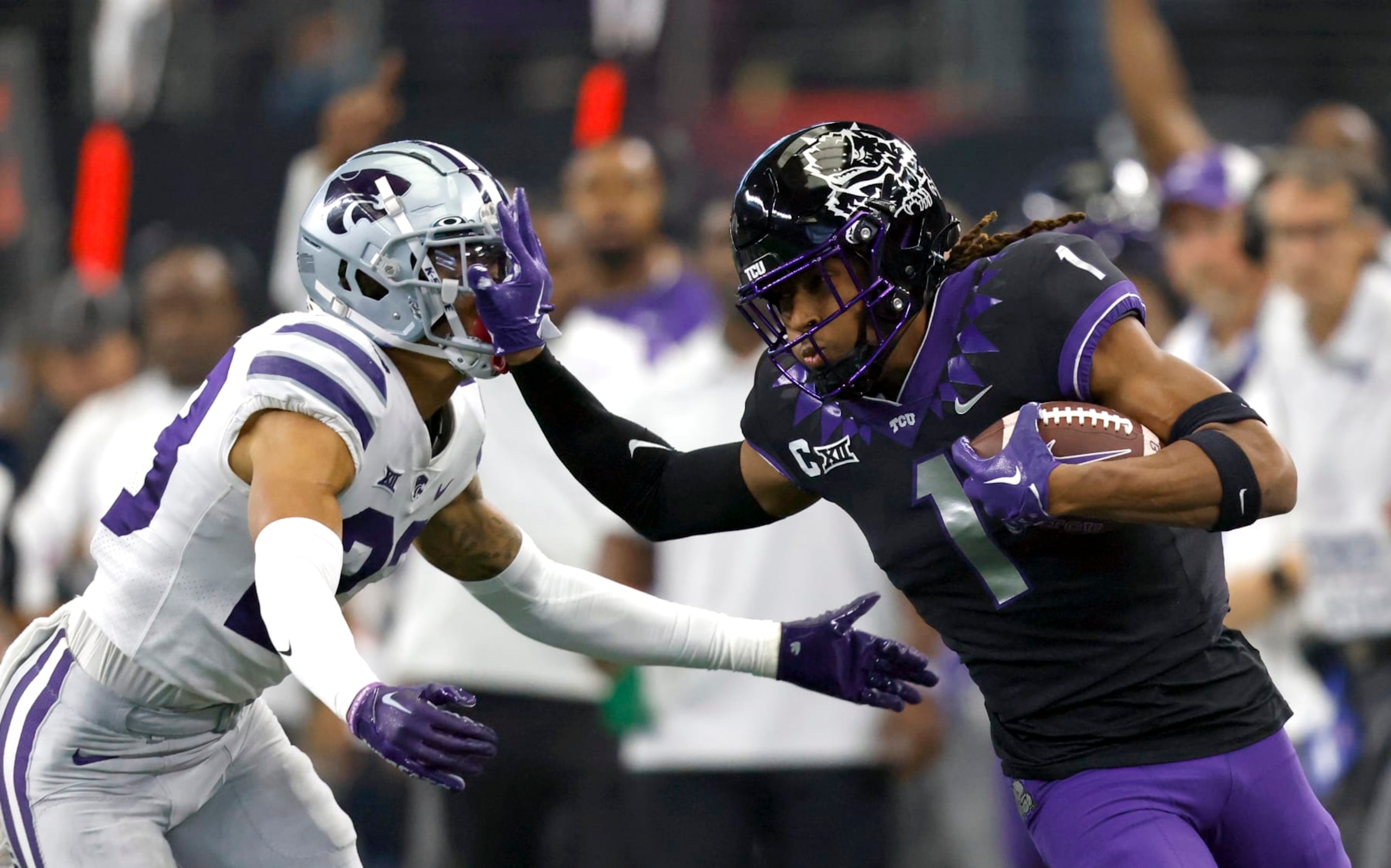 ARLINGTON, TX - DECEMBER 3: Quentin Johnston #1 of the TCU Horned Frogs stiff arms Julius Brents #23 of the Kansas State Wildcats in the first half of the Big 12 Football Championship at AT&T Stadium on December 3, 2022 in Arlington, Texas.  (Photo by Ron Jenkins/Getty Images)