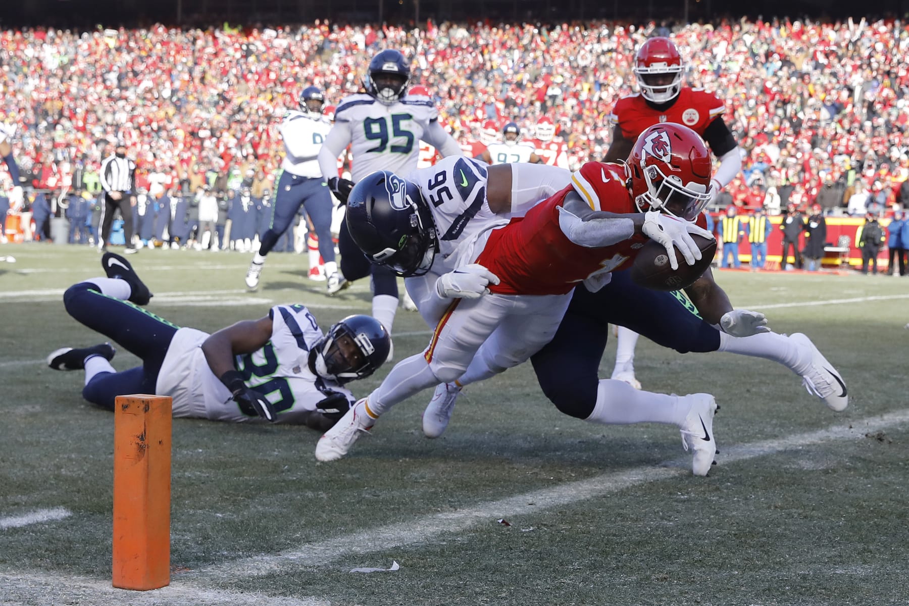 KANSAS CITY, MISSOURI - DECEMBER 24: Jerick McKinnon #1 of the Kansas City Chiefs dives past Myles Adams #95 of the Seattle Seahawks while scoring a receiving touchdown during the second quarter at Arrowhead Stadium on December 24, 2022 in Kansas City, Missouri. (Photo by David Eulitt/Getty Images)