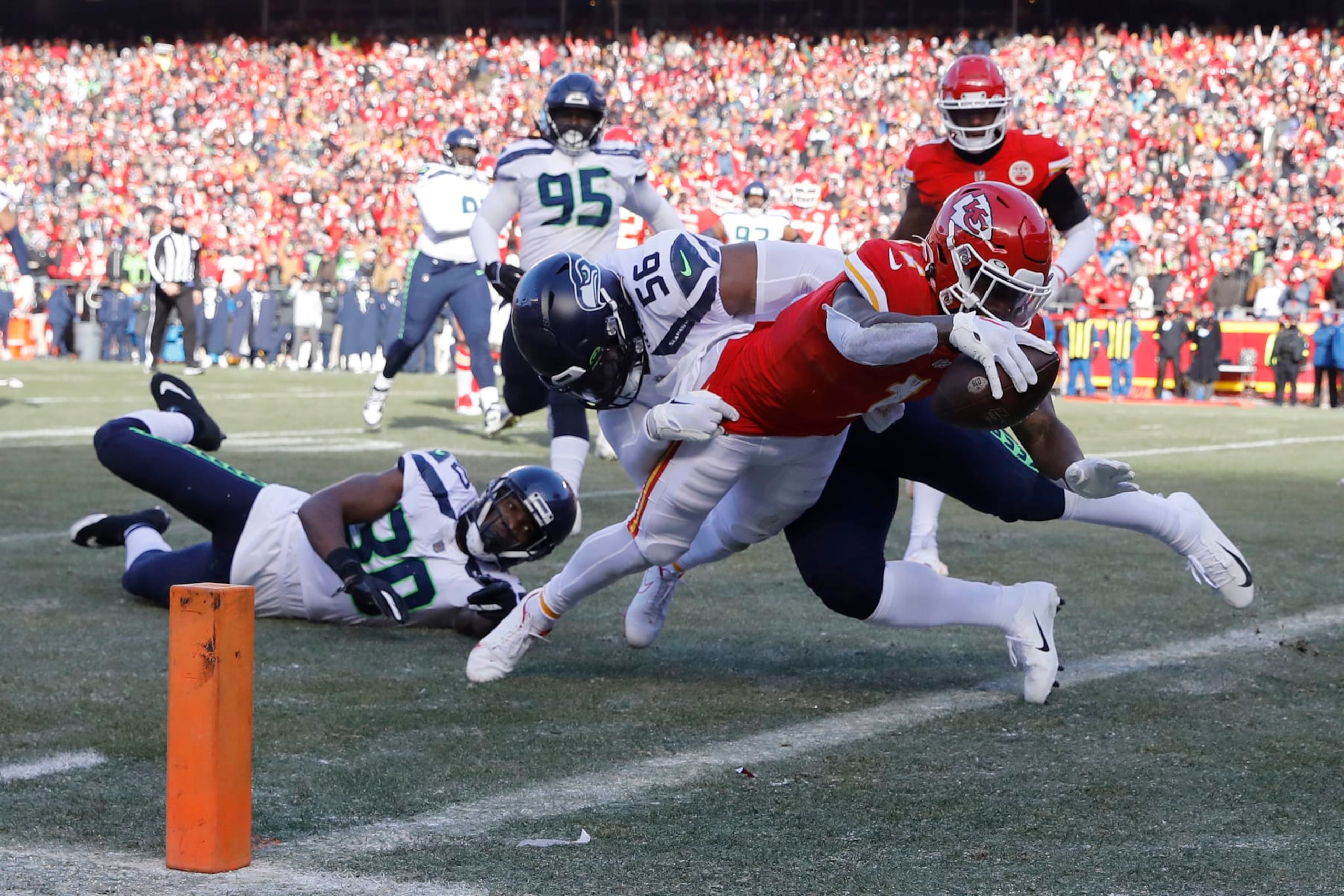 KANSAS CITY, MISSOURI - DECEMBER 24: Jerick McKinnon #1 of the Kansas City Chiefs dives past Myles Adams #95 of the Seattle Seahawks while scoring a receiving touchdown during the second quarter at Arrowhead Stadium on December 24, 2022 in Kansas City, Missouri. (Photo by David Eulitt/Getty Images)