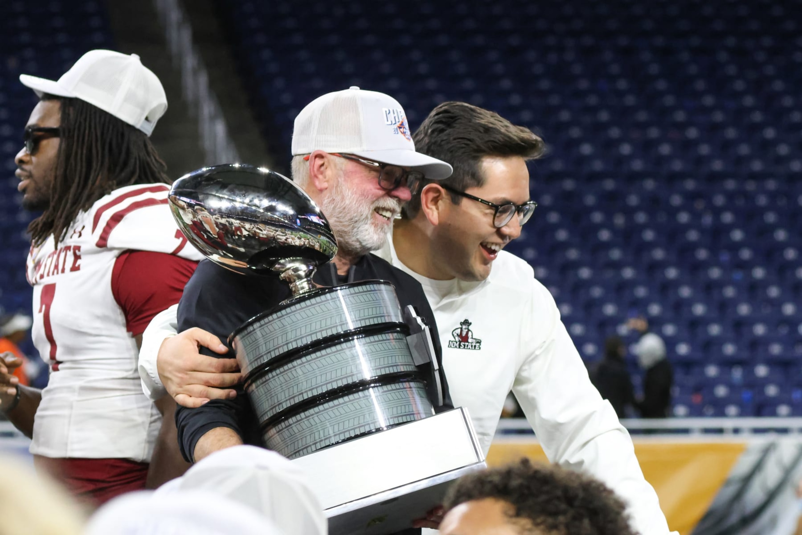DETROIT, MI - DECEMBER 26:  New Mexico State Aggies head coach Jerry Kill holds onto the championship trophy as he poses for photographs during the awards ceremony following the Quick Lane Bowl college football game between the New Mexico State Aggies and the Bowling Green Falcons on December 26, 2022 at Ford Field in Detroit, Michigan.  (Photo by Scott W. Grau/Icon Sportswire via Getty Images)