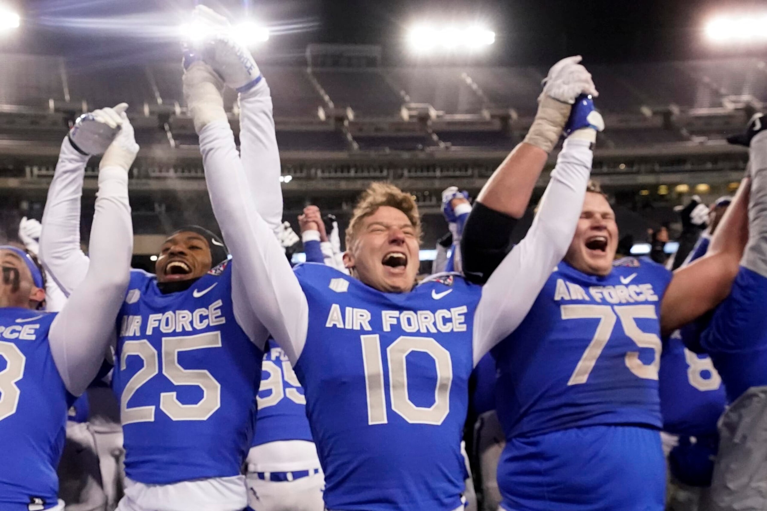 Air Force's Jalen Mergerson (10), Ethan Jackman (75) and Jamari Bellamy (25) cheer after the team's 30-15 win over Baylor in the Armed Forces Bowl NCAA college football game in Fort Worth, Texas, Thursday, Dec. 22, 2022. (AP Photo/LM Otero)