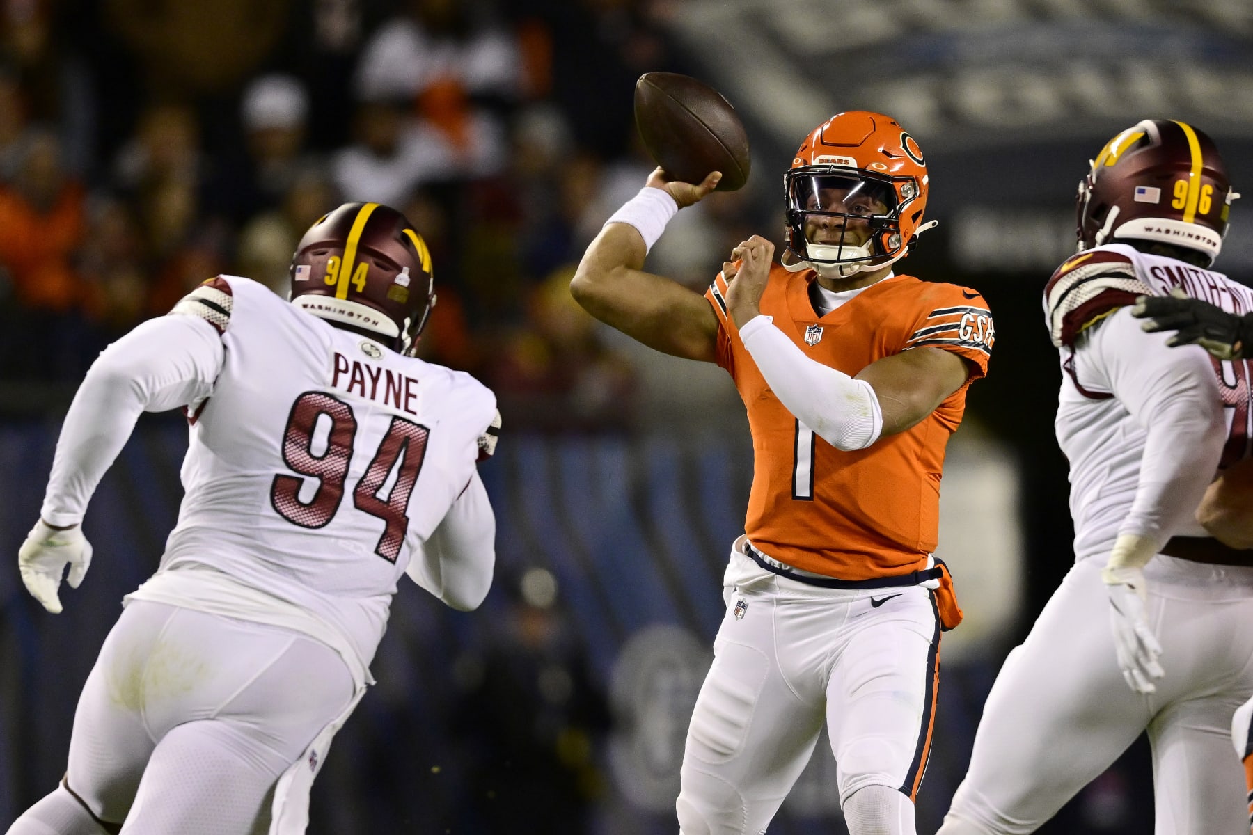CHICAGO, ILLINOIS - OCTOBER 13: Justin Fields #1 of the Chicago Bears passes while pressured by Daron Payne #94 of the Washington Commanders during the first quarter at Soldier Field on October 13, 2022 in Chicago, Illinois. (Photo by Quinn Harris/Getty Images)