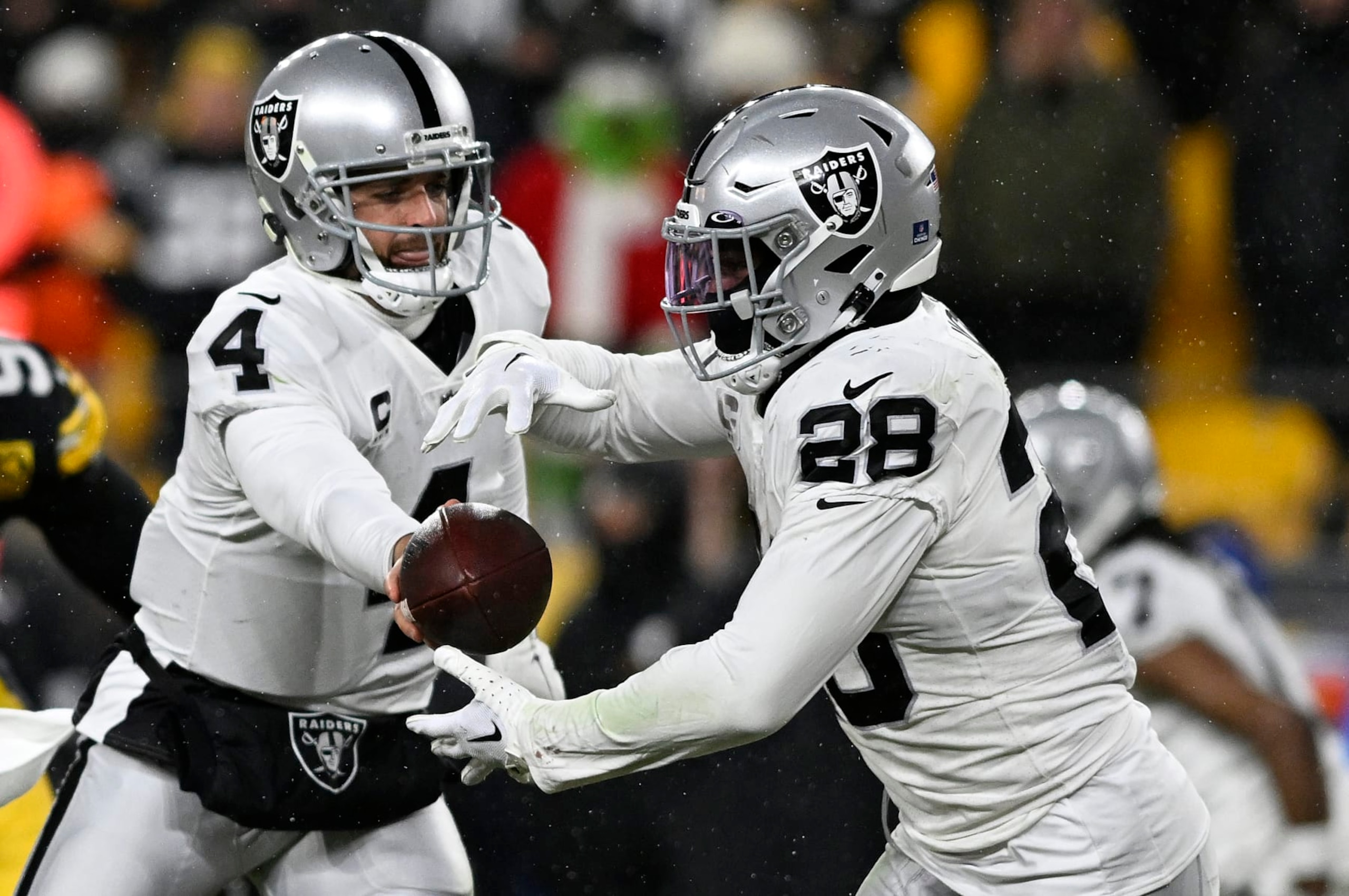 PITTSBURGH, PENNSYLVANIA - DECEMBER 24: Derek Carr #4 of the Las Vegas Raiders hands the ball off Josh Jacobs #28 of the Las Vegas Raiders during the third quarter against the Pittsburgh Steelers at Acrisure Stadium on December 24, 2022 in Pittsburgh, Pennsylvania. (Photo by Gaelen Morse/Getty Images)