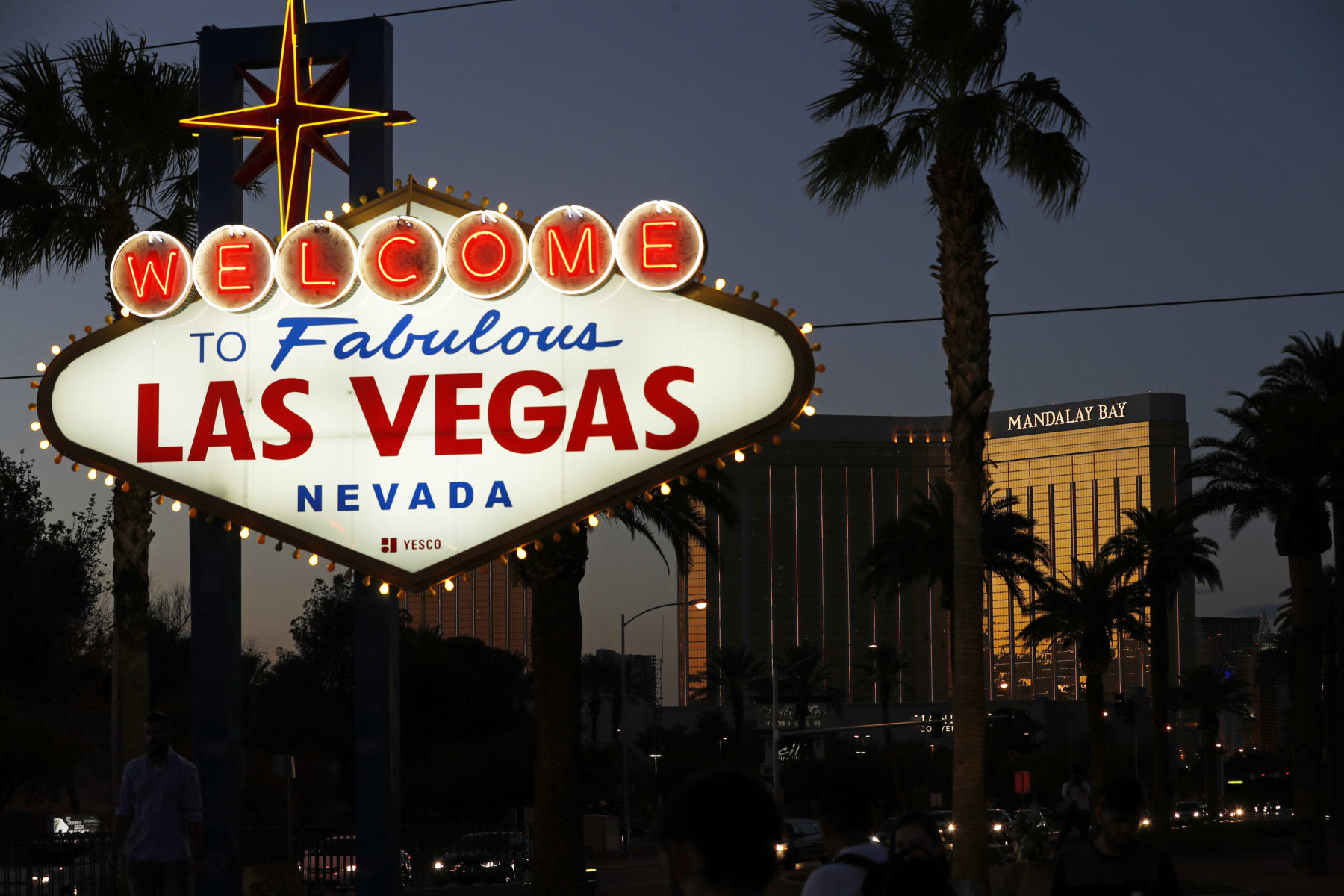 FILE - In this Sept. 21, 2018, file photo, the Mandalay Bay hotel and casino reflects the last sunlight of the day along the Las Vegas Strip in Nevada. Casino owner MGM Resorts International is bringing the coronavirus vaccine to its Las Vegas Strip employees, with the opening of an inoculation clinic at the Mandalay Bay resort convention center. Easing vaccine availability for perhaps thousands of hotel and hospitality workers comes with the University of Nevada, Las Vegas setting a July 1, 2021, date to return to in-person activities. (AP Photo/John Locher, File)