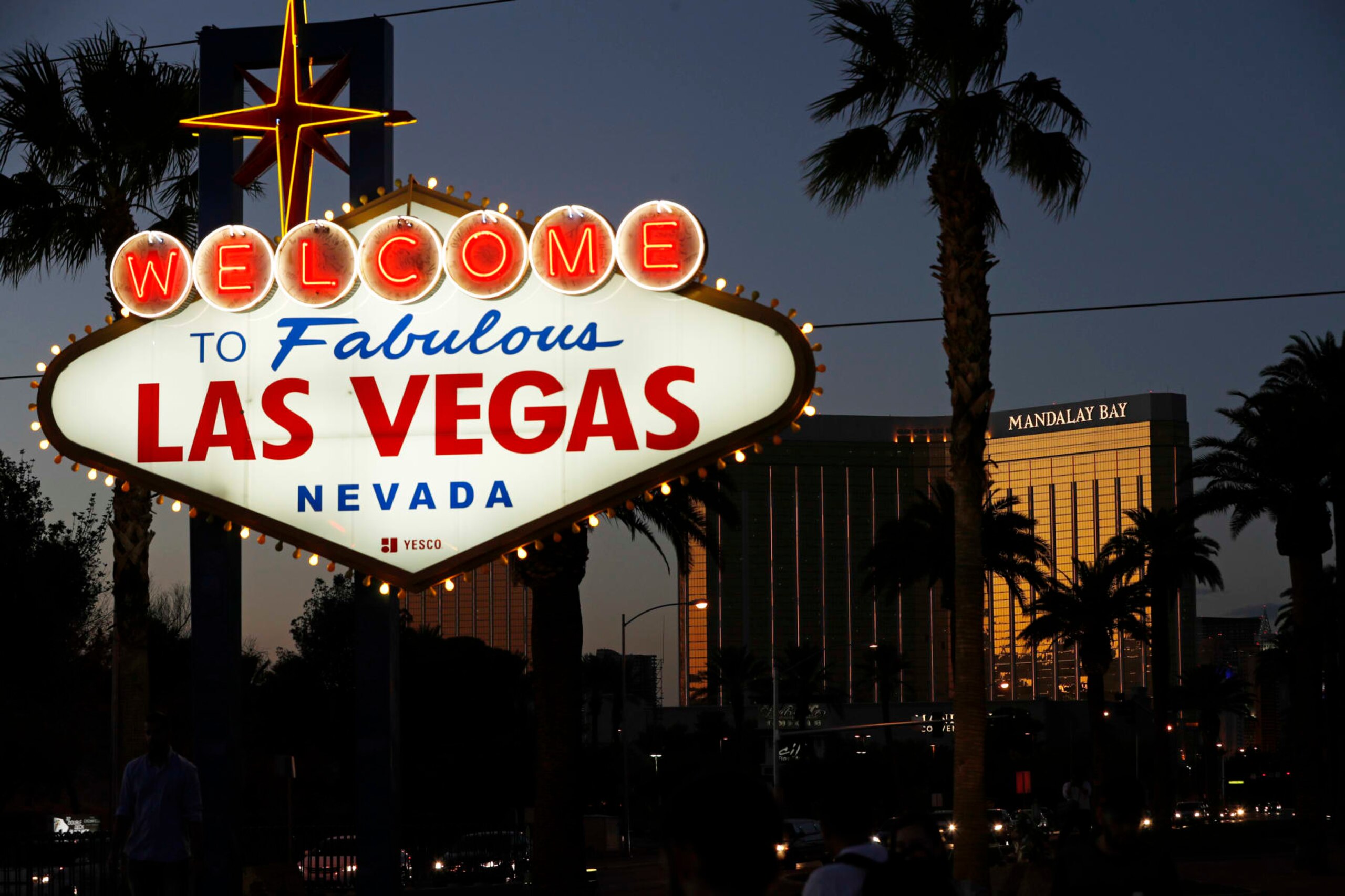 FILE - In this Sept. 21, 2018, file photo, the Mandalay Bay hotel and casino reflects the last sunlight of the day along the Las Vegas Strip in Nevada. Casino owner MGM Resorts International is bringing the coronavirus vaccine to its Las Vegas Strip employees, with the opening of an inoculation clinic at the Mandalay Bay resort convention center. Easing vaccine availability for perhaps thousands of hotel and hospitality workers comes with the University of Nevada, Las Vegas setting a July 1, 2021, date to return to in-person activities. (AP Photo/John Locher, File)
