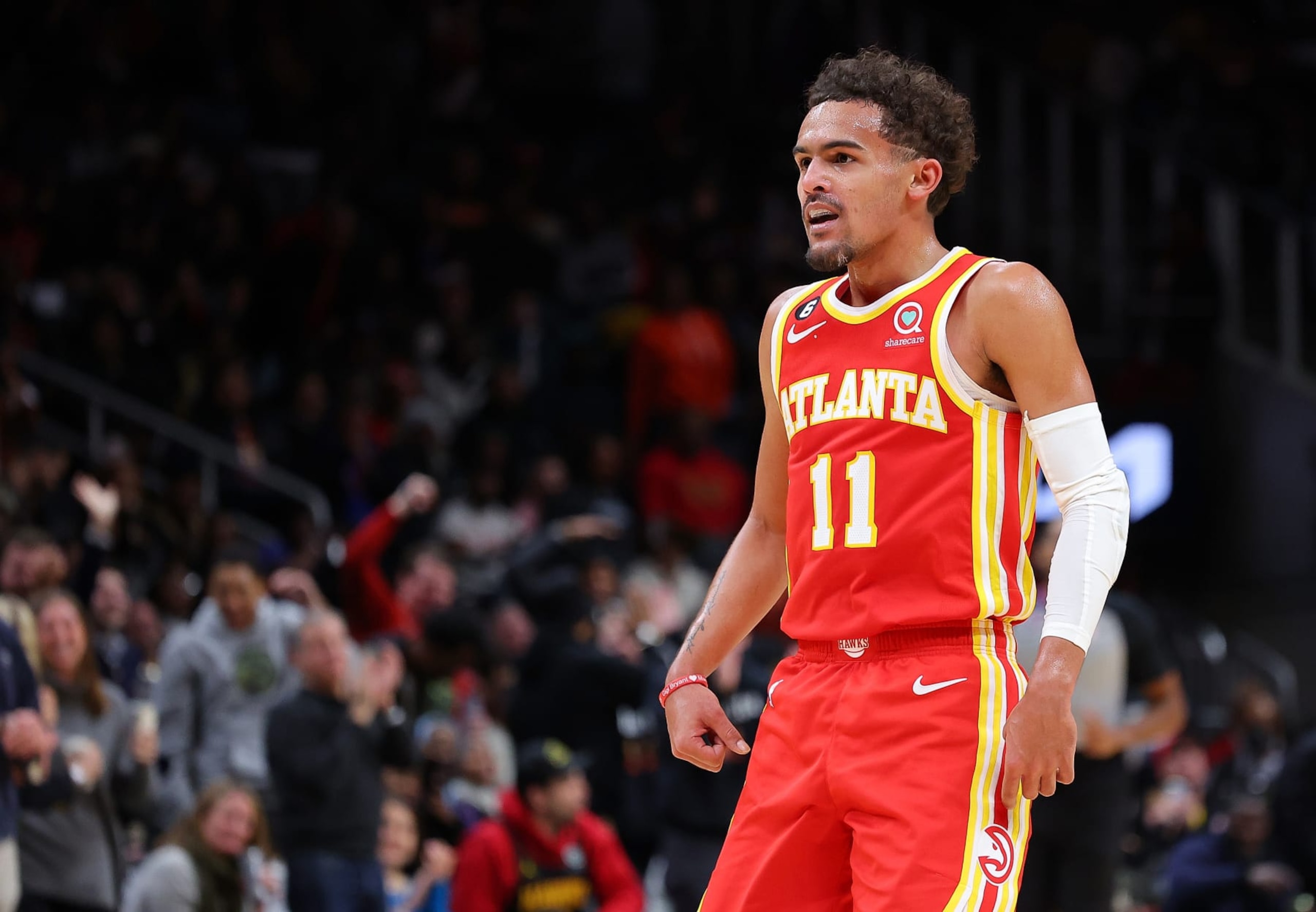 ATLANTA, GEORGIA - DECEMBER 23:  Trae Young #11 of the Atlanta Hawks reacts after passing to John Collins #20 for a dunk against the Detroit Pistons during the third quarter at State Farm Arena on December 23, 2022 in Atlanta, Georgia.  NOTE TO USER: User expressly acknowledges and agrees that, by downloading and or using this photograph, User is consenting to the terms and conditions of the Getty Images License Agreement.  (Photo by Kevin C. Cox/Getty Images)