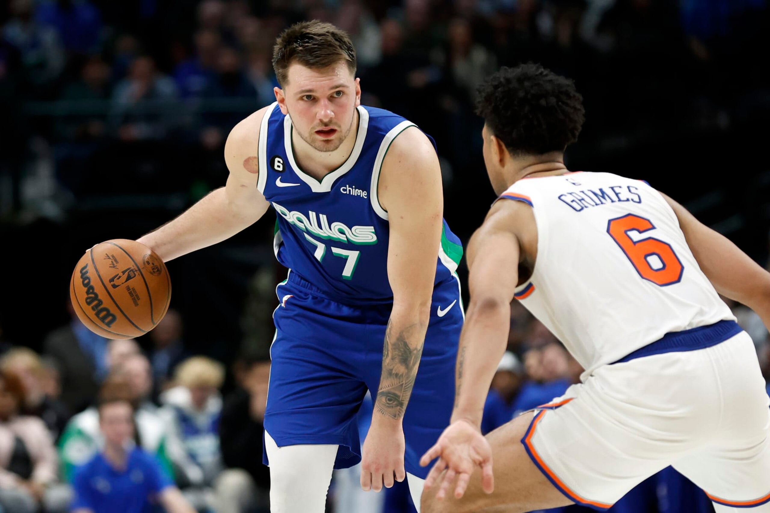 DALLAS, TEXAS - DECEMBER 27:  Luka Doncic #77 of the Dallas Mavericks dribbles up court while defended by Quentin Grimes #6 of the New York Knicks in the second half at American Airlines Center on December 27, 2022 in Dallas, Texas. NOTE TO USER: User expressly acknowledges and agrees that, by downloading and or using this photograph, User is consenting to the terms and conditions of the Getty Images License Agreement.  (Photo by Tim Heitman/Getty Images)