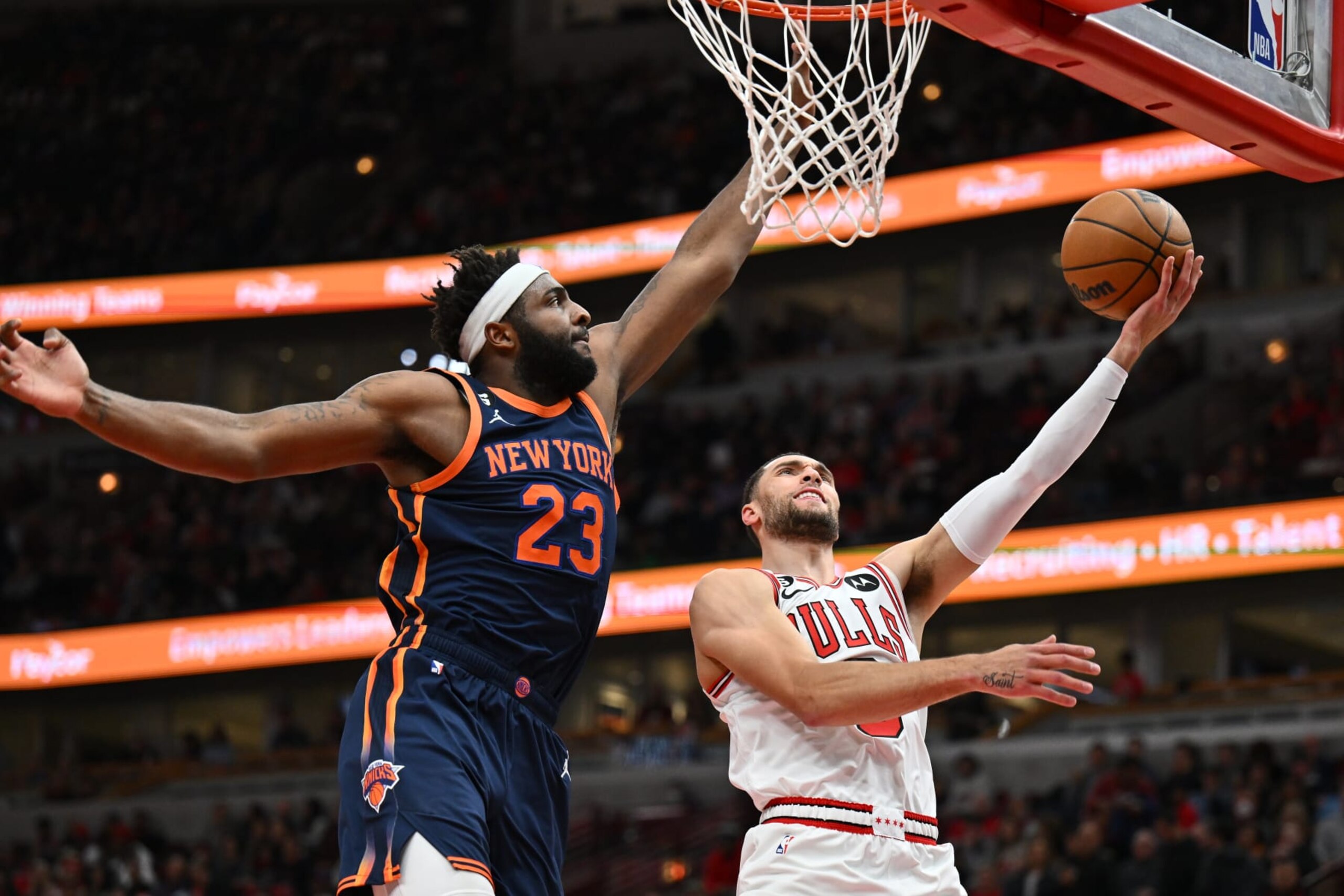 CHICAGO, ILLINOIS - DECEMBER 16: Zach Lavine #8 of the Chicago Bulls goes in for a lay up past Mitchell Robinson #23 of the New York Knicks in the second half on December 16, 2022 at the United Center in Chicago, Illinois. New York defeated Chicago 114-91. NOTE TO USER: User expressly acknowledges and agrees that, by downloading and or using this photograph, User is consenting to the terms and conditions of the Getty Images License Agreement. (Photo by Jamie Sabau/Getty Images)