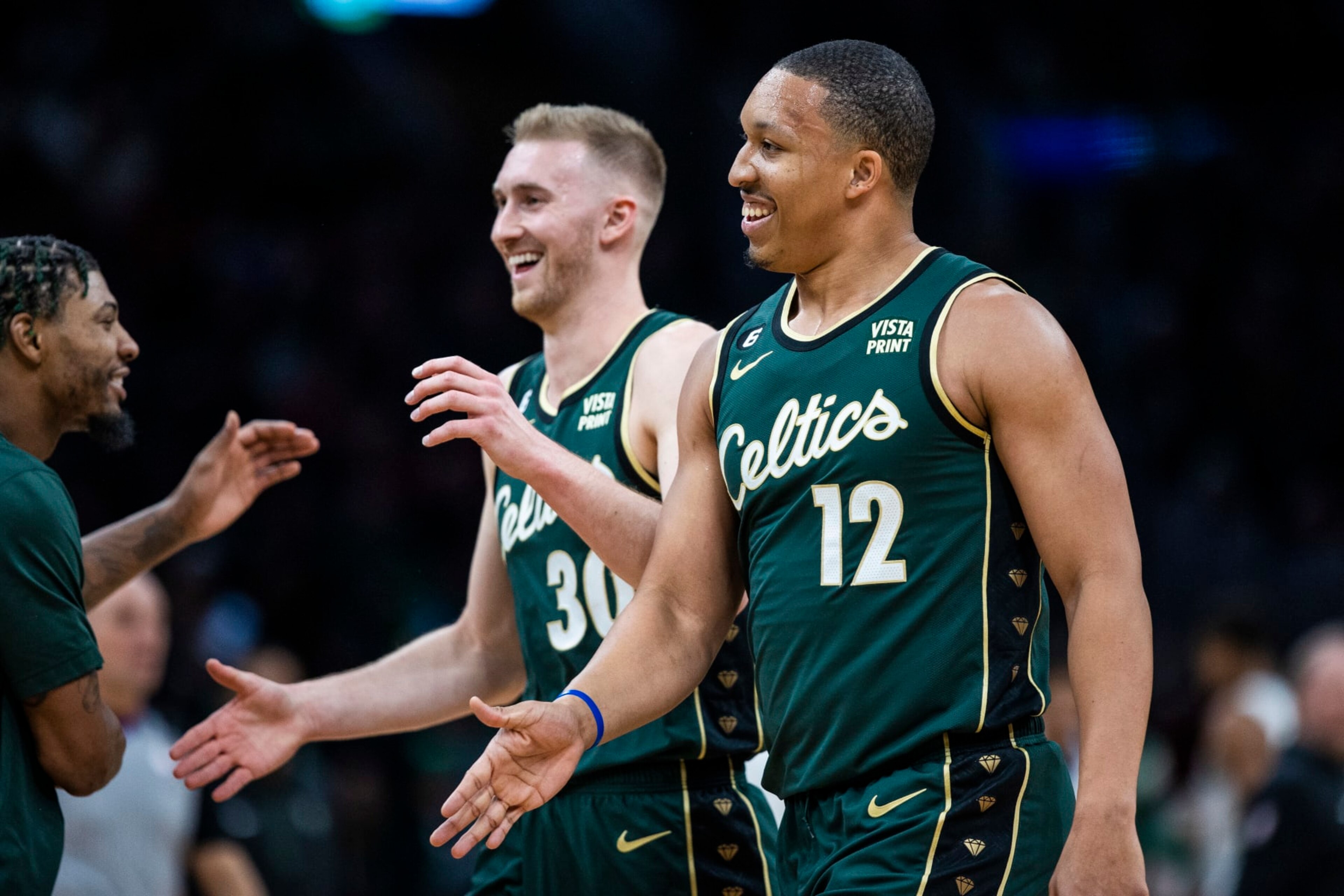 Boston, MA - December 25: Boston Celtics PF Grant Williams, right, and SF Sam Hauser smile as they return to the bench. The Celtics beat the Milwaukee Bucks, 139-118. (Photo by Erin Clark/The Boston Globe via Getty Images)