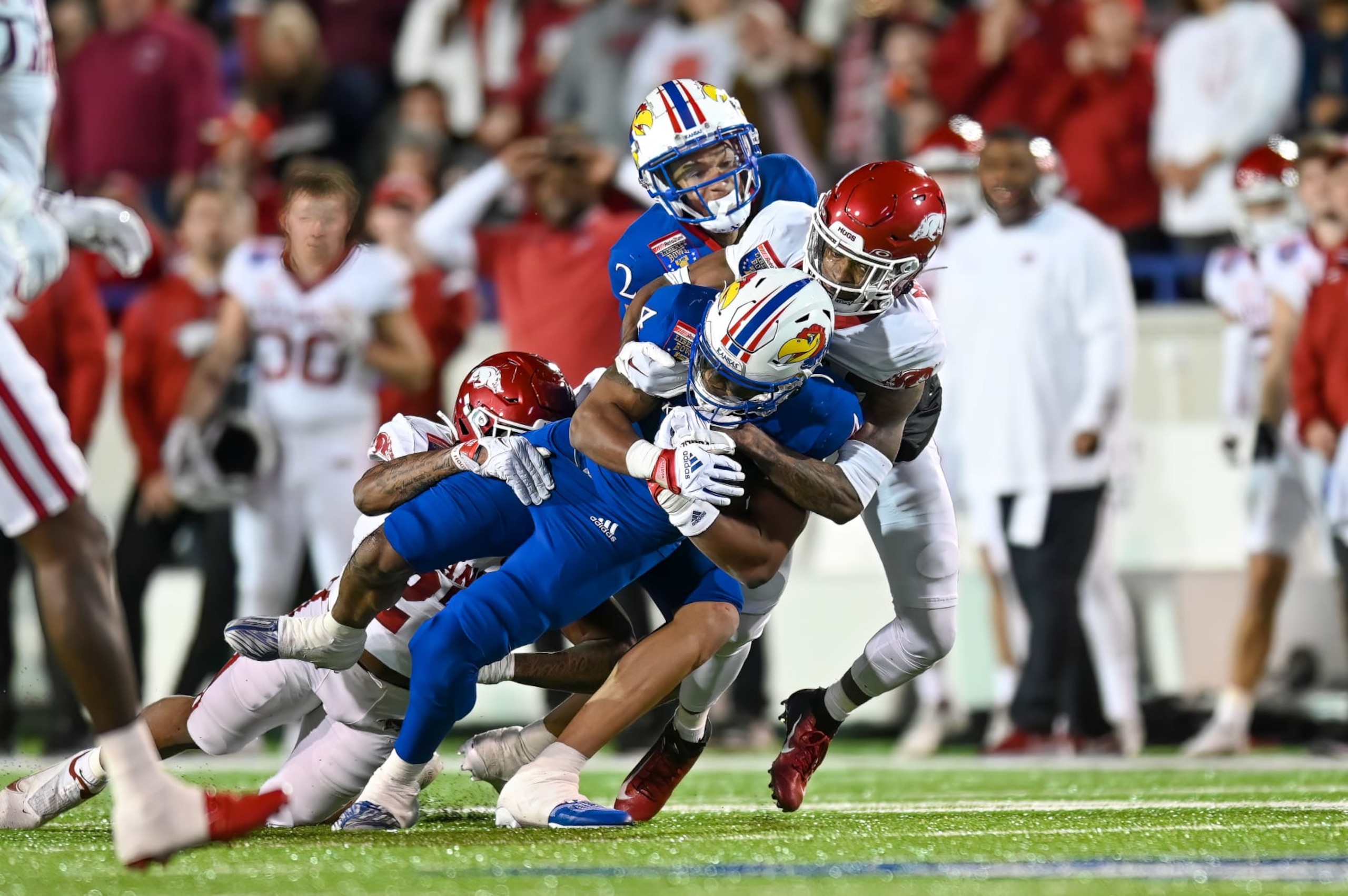 Kansas' Devin Neal is tackled by Arkansas' Hudson Clark.