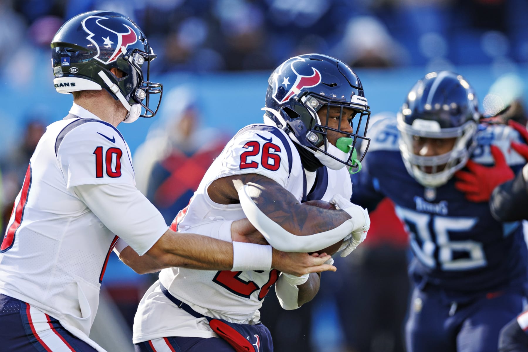 NASHVILLE, TENNESSEE - DECEMBER 24:  Davis Mills #10 hands off the ball to Royce Freeman #26 of the Houston Texans during a game against the Tennessee Titans at Nissan Stadium on December 24, 2022 in Nashville, Tennessee. The Texans defeated the Titans 19-14. (Photo by Wesley Hitt/Getty Images)