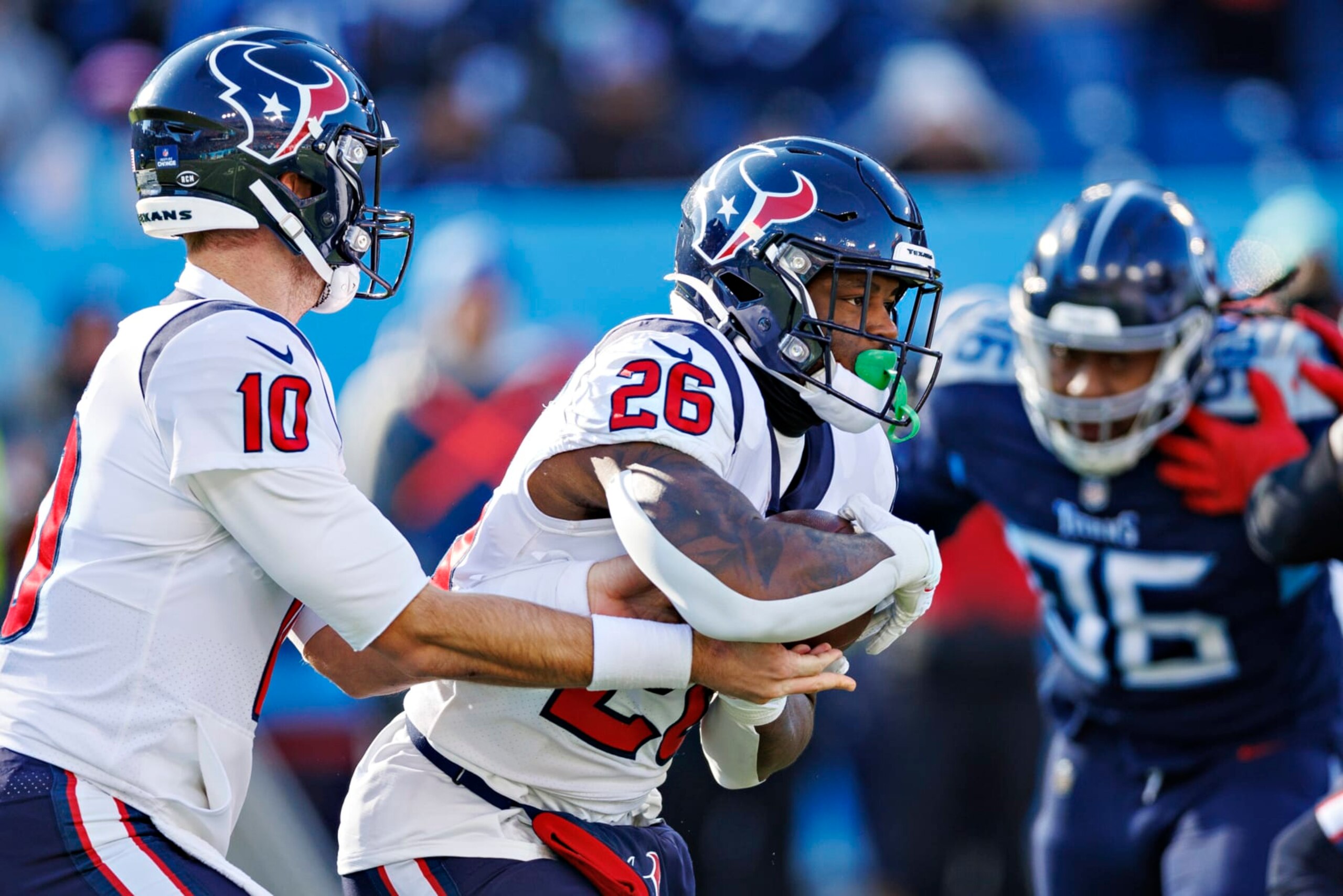 NASHVILLE, TENNESSEE - DECEMBER 24:  Davis Mills #10 hands off the ball to Royce Freeman #26 of the Houston Texans during a game against the Tennessee Titans at Nissan Stadium on December 24, 2022 in Nashville, Tennessee. The Texans defeated the Titans 19-14. (Photo by Wesley Hitt/Getty Images)