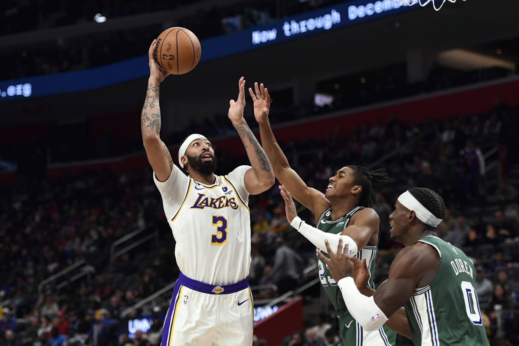 Los Angeles Lakers center Anthony Davis, left, shoots over Detroit Pistons guard Jaden Ivey and center Jalen Duren during the second half of an NBA basketball game, Sunday, Dec. 11, 2022, in Detroit. (AP Photo/Jose Juarez)