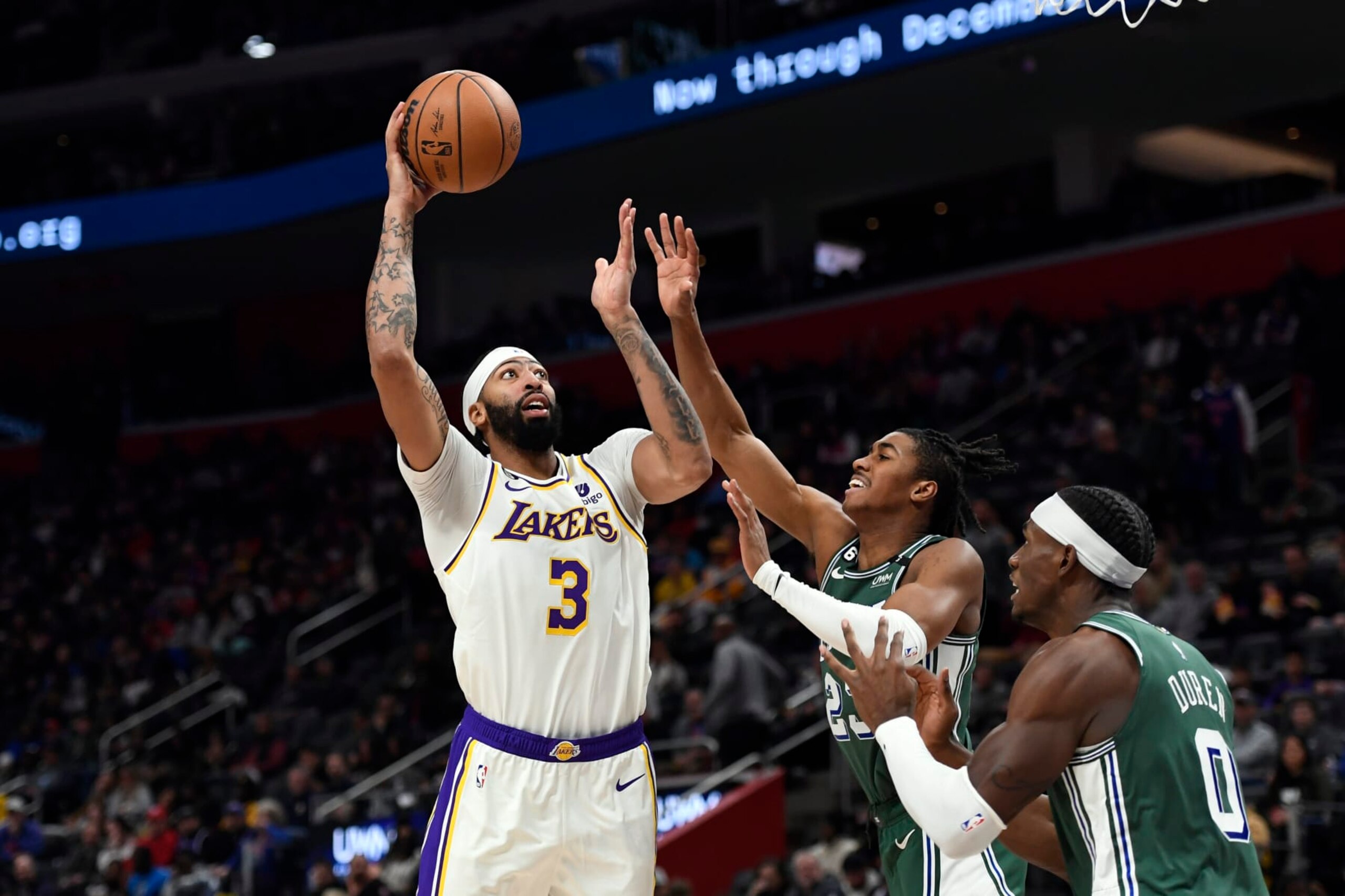Los Angeles Lakers center Anthony Davis, left, shoots over Detroit Pistons guard Jaden Ivey and center Jalen Duren during the second half of an NBA basketball game, Sunday, Dec. 11, 2022, in Detroit. (AP Photo/Jose Juarez)