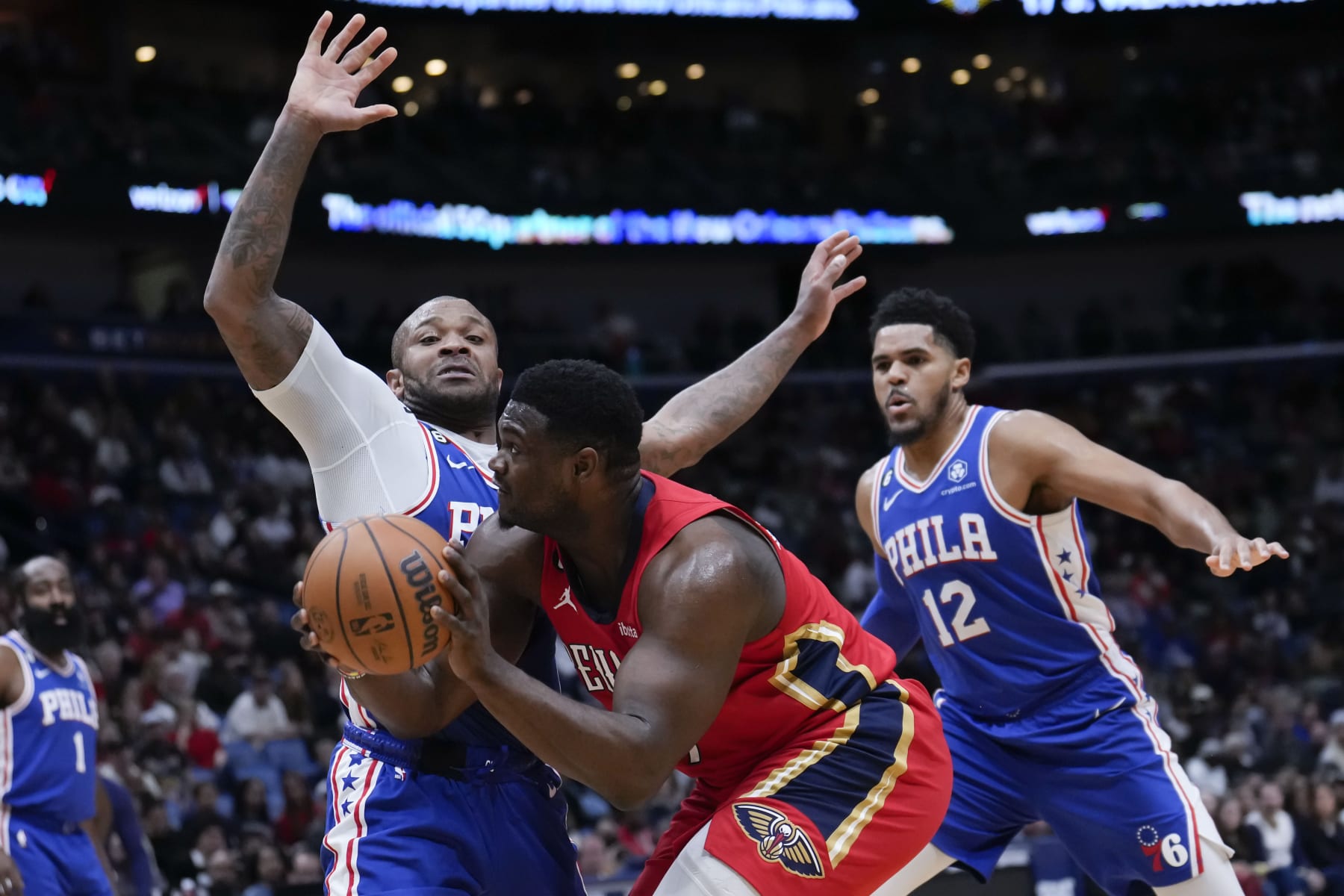 New Orleans Pelicans forward Zion Williamson (1) drives against Philadelphia 76ers forward P.J. Tucker and forward Tobias Harris (12) in the first half of an NBA basketball game in New Orleans, Friday, Dec. 30, 2022. (AP Photo/Gerald Herbert)