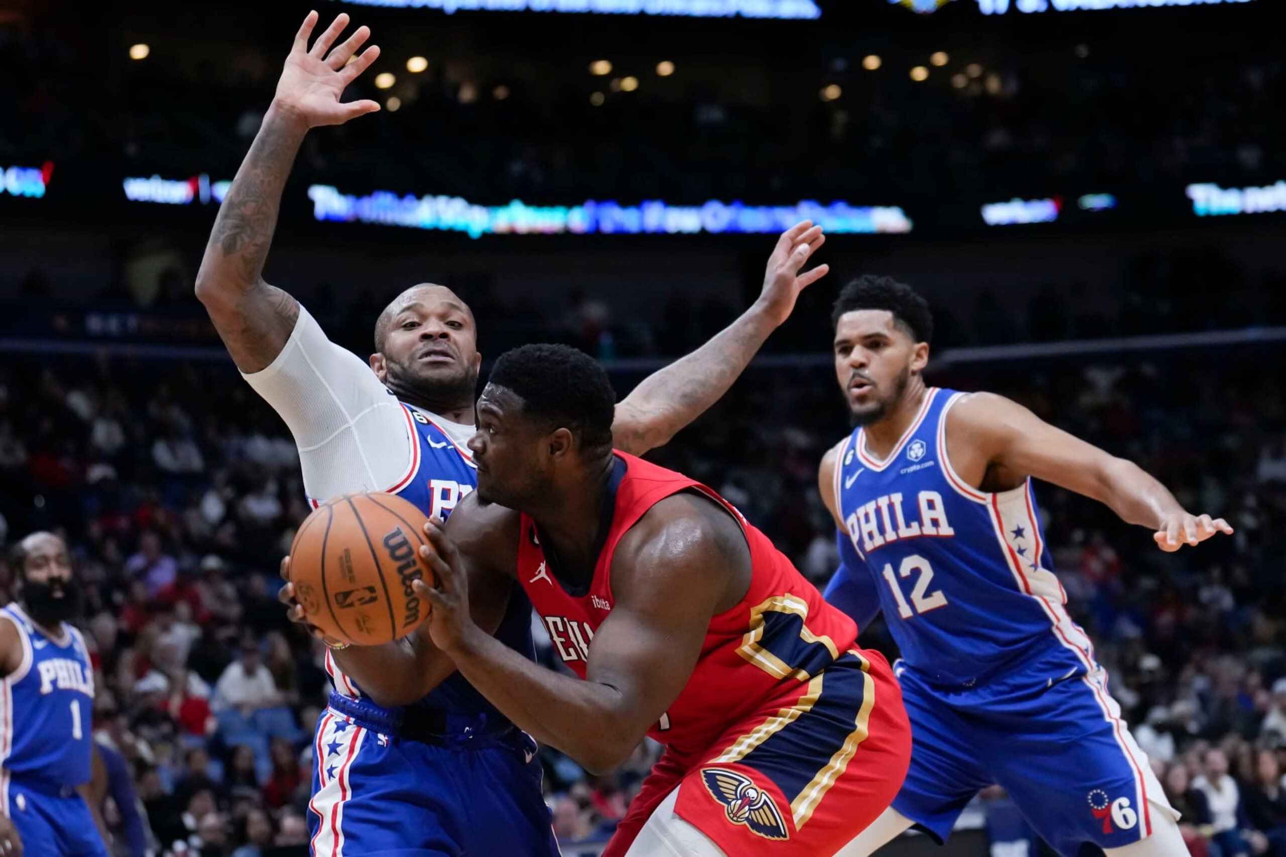 New Orleans Pelicans forward Zion Williamson (1) drives against Philadelphia 76ers forward P.J. Tucker and forward Tobias Harris (12) in the first half of an NBA basketball game in New Orleans, Friday, Dec. 30, 2022. (AP Photo/Gerald Herbert)