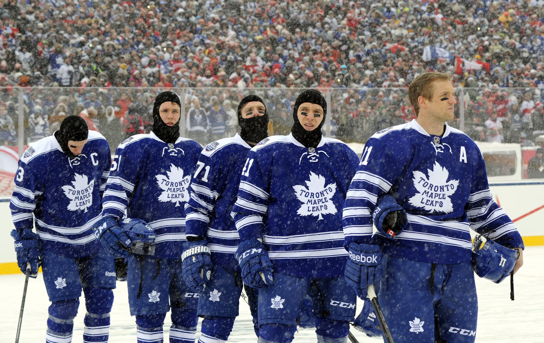 TORONTO , ON - JANUARY 1:  The Toronto Maple Leafs stand for the singing of the national anthem before action against the Detroit Red Wings during NHL game action during the 2014 Bridgestone NHL Winter Classic January 1, 2014 at Michigan Stadium in Ann Arbor, Michigan.  (Photo by Graig Abel/NHLI via Getty Images)