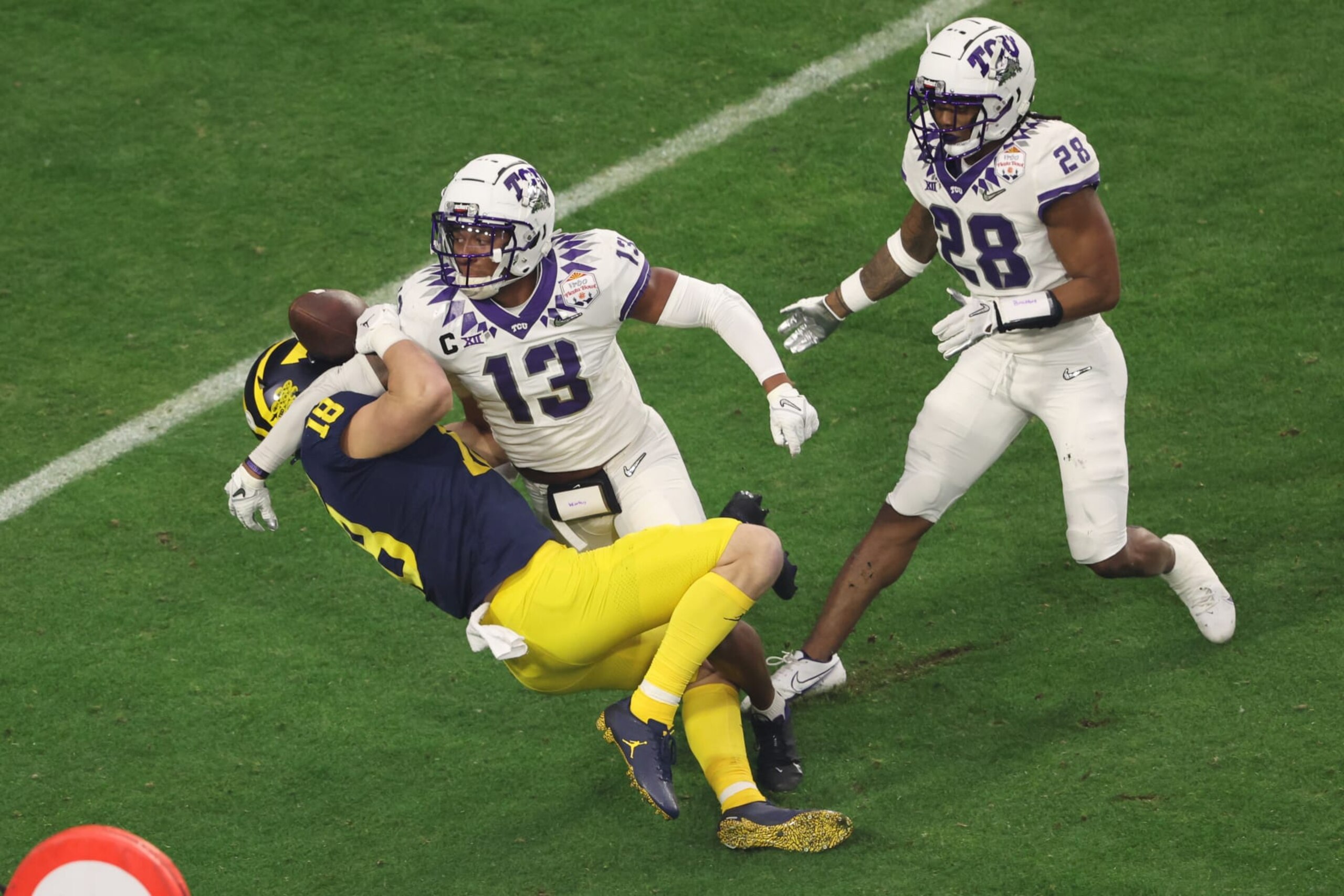 TCU's Dee Winters breaks up a pass to Michigan's Colston Loveland