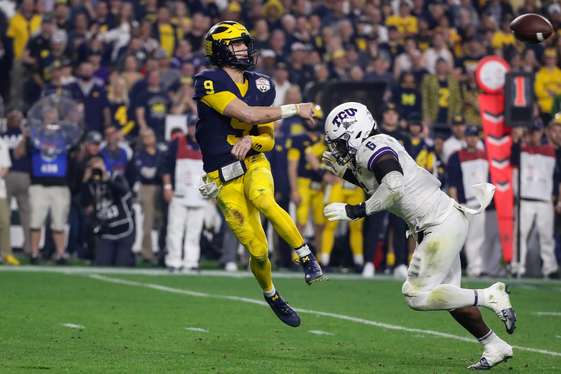 Michigan's J.J. McCarthy pressured by TCU's Jamoi Hodge.