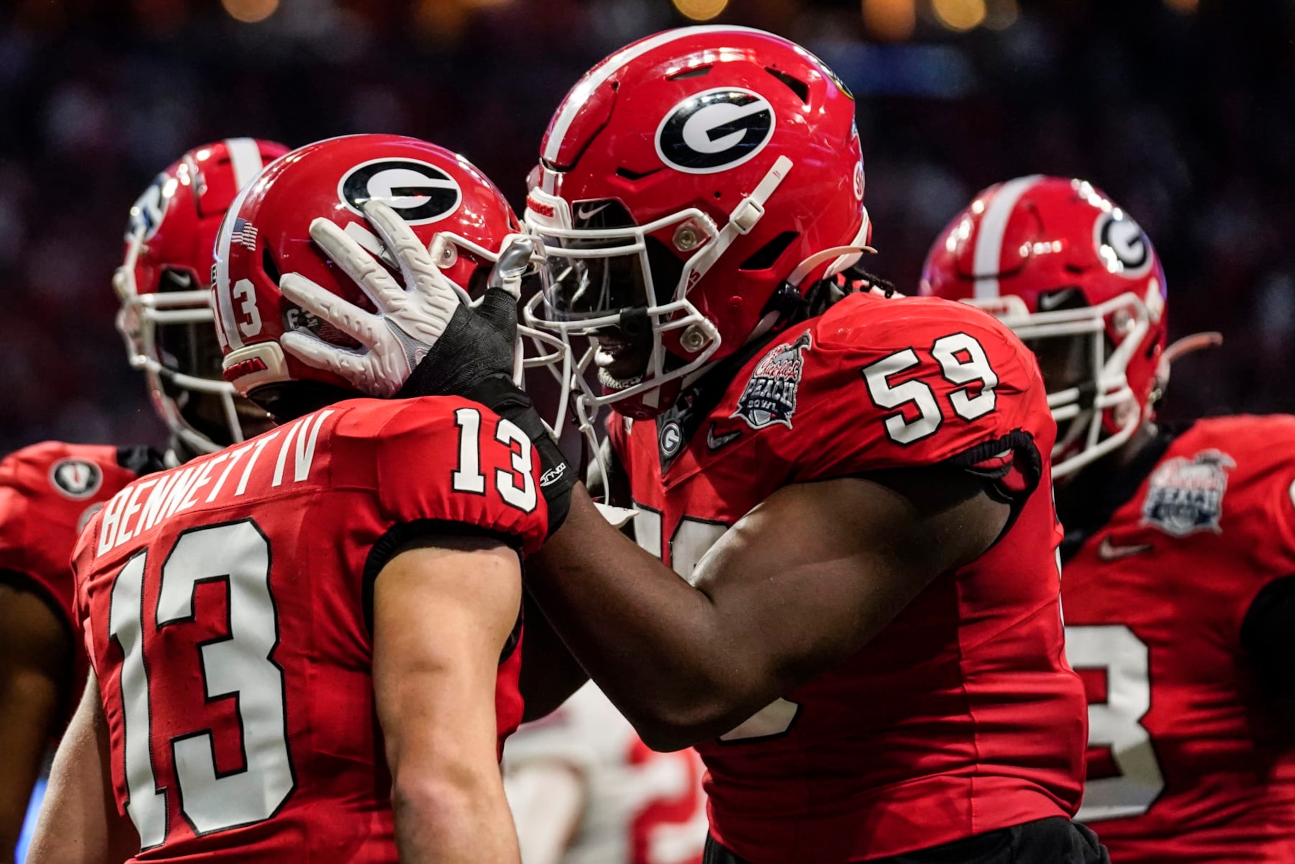 Georgia quarterback Stetson Bennett (13) celebrates his touchdown run with Georgia offensive lineman Broderick Jones (59) during the first half of the Peach Bowl NCAA college football semifinal playoff game against Ohio State, Saturday, Dec. 31, 2022, in Atlanta. (AP Photo/Brynn Anderson)