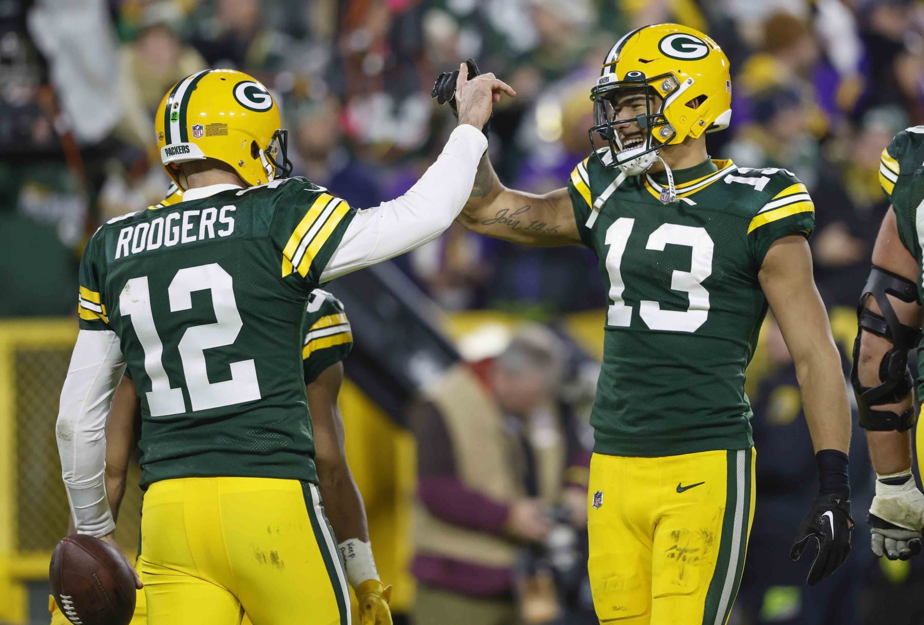 Green Bay Packers quarterback Aaron Rodgers (12) reacts with Green Bay Packers wide receiver Allen Lazard (13) after Rodgers ran in for a touchdown against the Minnesota Vikings during an NFL football game Sunday, Jan. 1, 2023, in Green Bay, Wis. (AP Photo/Jeffrey Phelps)