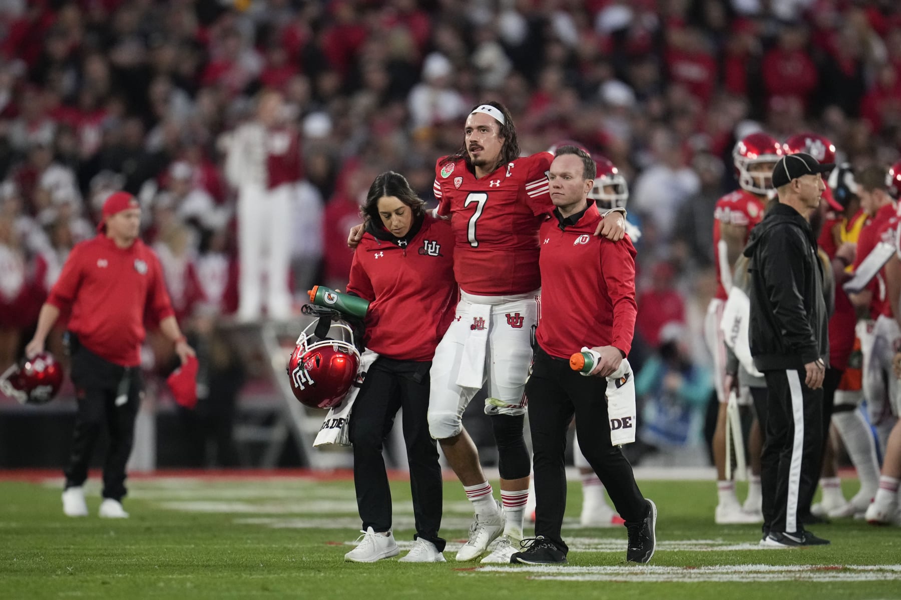 Utah quarterback Cameron Rising (7) is helped off the field during the second half in the Rose Bowl NCAA college football game against Penn State Monday, Jan. 2, 2023, in Pasadena, Calif. (AP Photo/Marcio Jose Sanchez)
