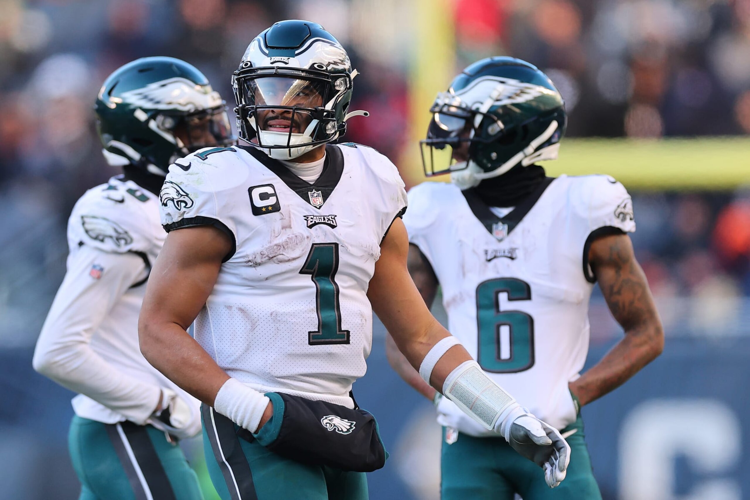 CHICAGO, ILLINOIS - DECEMBER 18: Jalen Hurts #1 of the Philadelphia Eagles talks with Quez Watkins #16 and DeVonta Smith #6 against the Chicago Bears at Soldier Field on December 18, 2022 in Chicago, Illinois. (Photo by Michael Reaves/Getty Images)