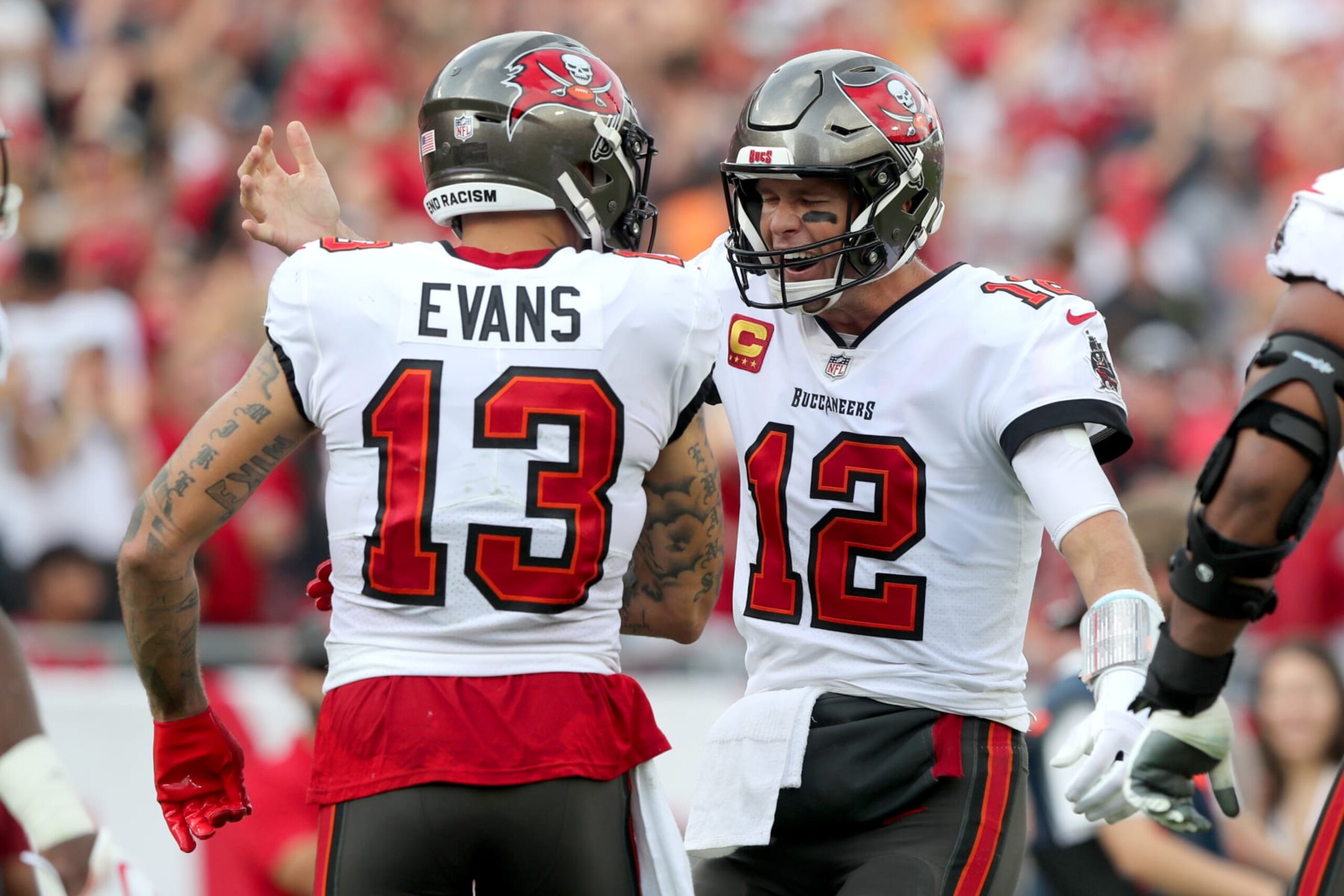 TAMPA, FL - JANUARY 01: Tampa Bay Buccaneers wide receiver Mike Evans (13) is hugged by his quarterback Tom Brady (12) after Brady threw him a touchdown pass during the regular season game between the Carolina Panthers and the Tampa Bay Buccaneers on January 01, 2023 at Raymond James Stadium in Tampa, Florida. (Photo by Cliff Welch/Icon Sportswire via Getty Images) TAMPA, FL - JANUARY 01: Tampa Bay Buccaneers wide receiver Mike Evans (13) is hugged by his quarterback Tom Brady (12) after Brady threw him a touchdown pass during the regular season game between the Carolina Panthers and the Tampa Bay Buccaneers on January 01, 2023 at Raymond James Stadium in Tampa, Florida. (Photo by Cliff Welch/Icon Sportswire via Getty Images)