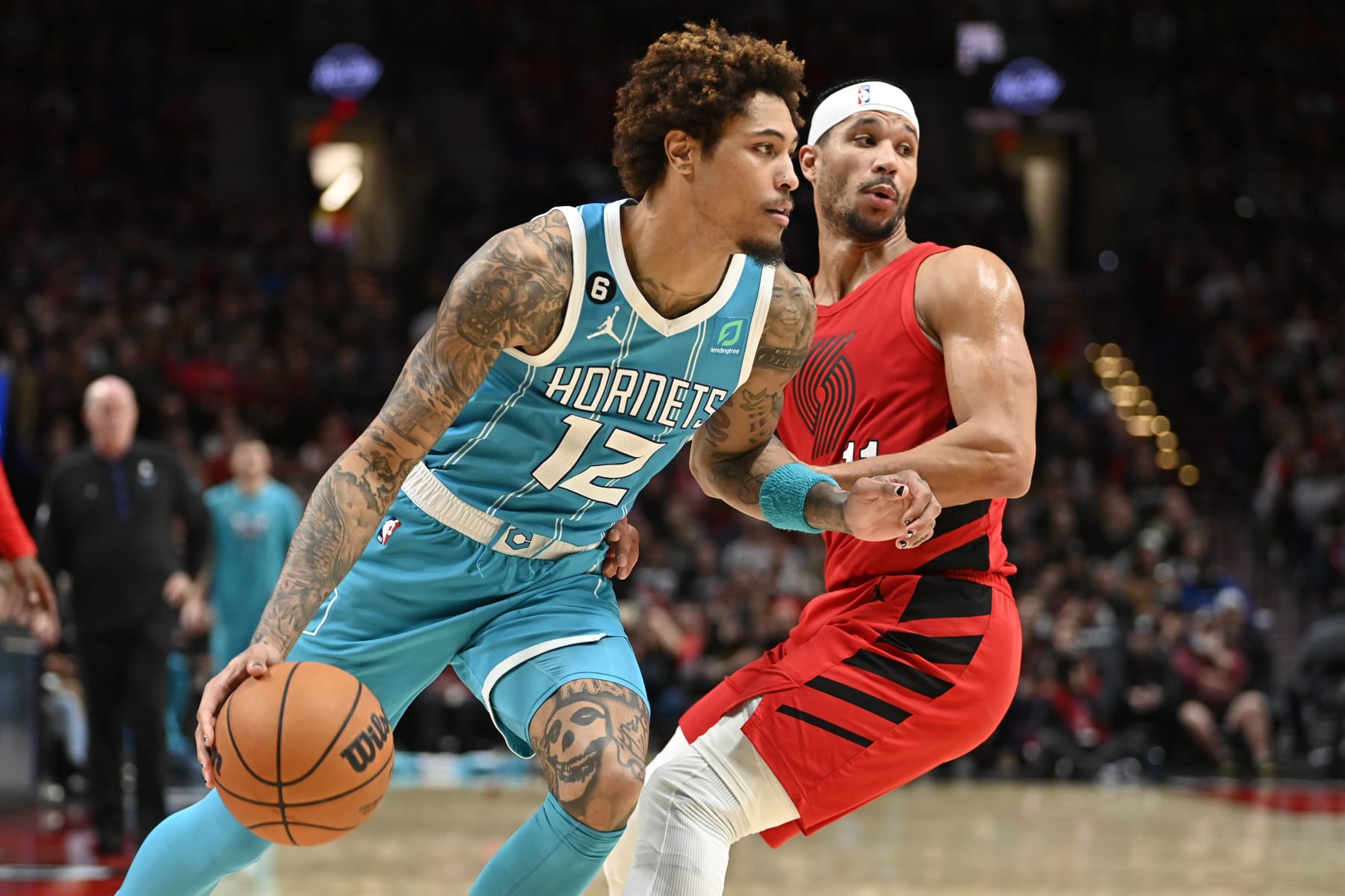 PORTLAND, OREGON - DECEMBER 26: Kelly Oubre Jr. #12 of the Charlotte Hornets drives against Josh Hart #11 of the Portland Trail Blazers during the third quarter at the Moda Center on December 26, 2022 in Portland, Oregon. The Portland Trail Blazers won 124-113. TO USER: User expressly acknowledges and agrees that, by downloading and or using this photograph, User is consenting to the terms and conditions of the Getty Images License Agreement. (Photo by Alika Jenner/Getty Images)