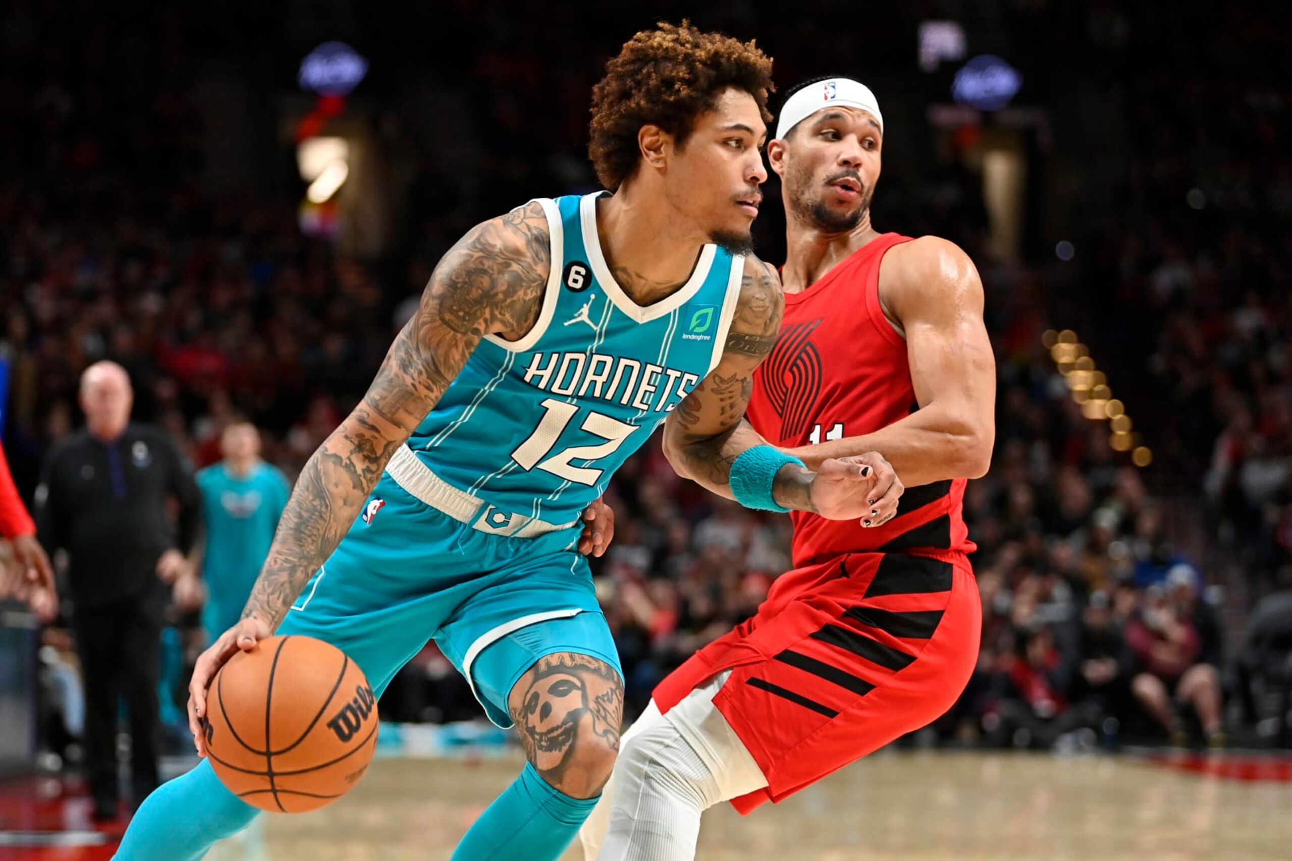 PORTLAND, OREGON - DECEMBER 26: Kelly Oubre Jr. #12 of the Charlotte Hornets drives against Josh Hart #11 of the Portland Trail Blazers during the third quarter at the Moda Center on December 26, 2022 in Portland, Oregon. The Portland Trail Blazers won 124-113. TO USER: User expressly acknowledges and agrees that, by downloading and or using this photograph, User is consenting to the terms and conditions of the Getty Images License Agreement. (Photo by Alika Jenner/Getty Images)