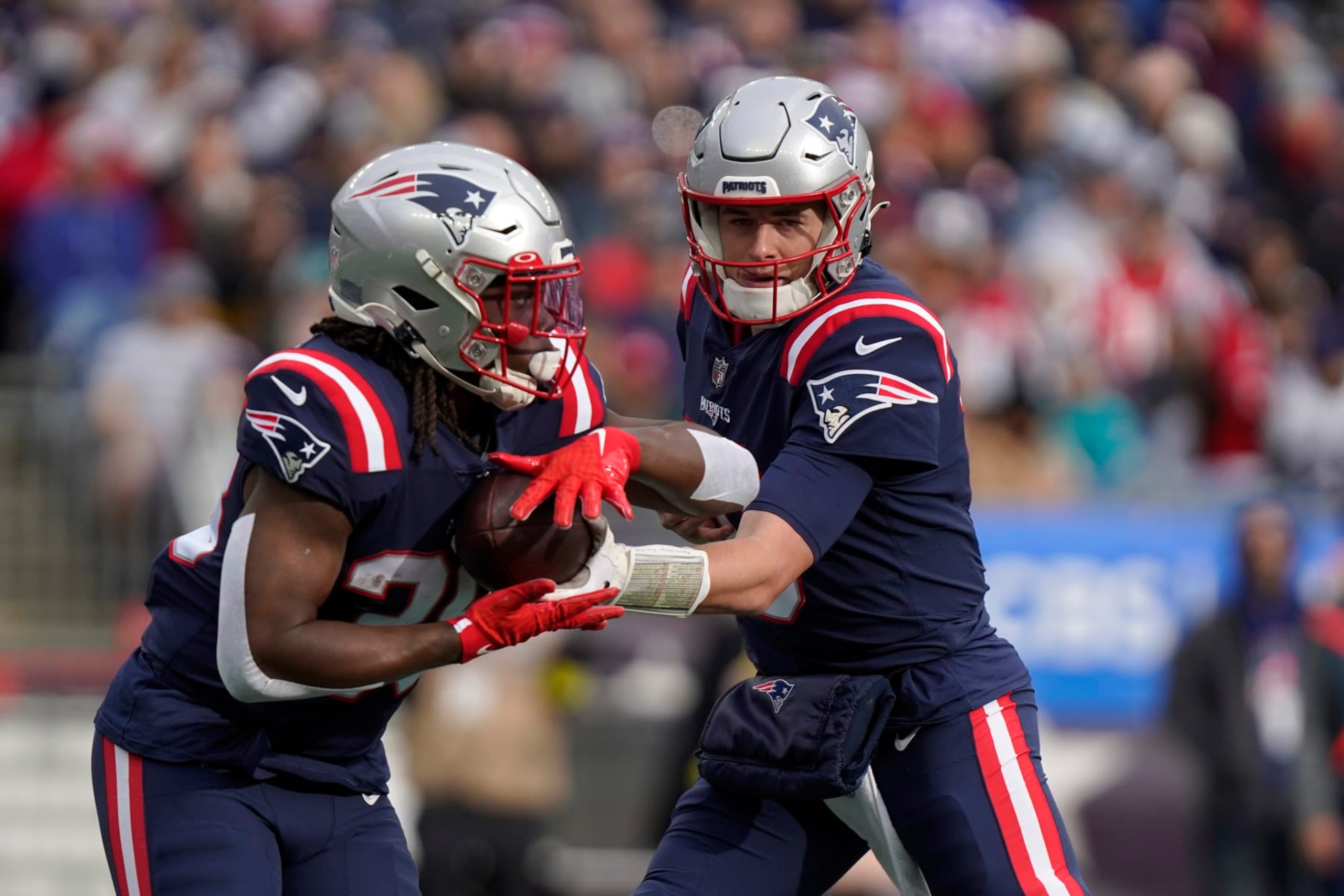 New England Patriots quarterback Mac Jones, right, hands off to running back Rhamondre Stevenson, left, in first half of an NFL football game, Sunday, Jan. 1, 2023, in Foxborough, Mass. (AP Photo/Steven Senne)