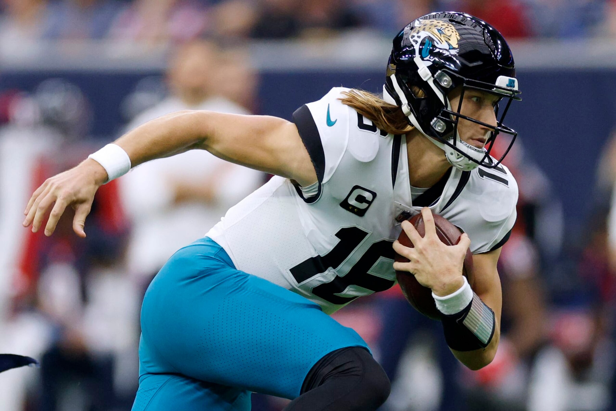 HOUSTON, TEXAS - JANUARY 01: Trevor Lawrence #16 of the Jacksonville Jaguars carries the ball against the Houston Texans during the first quarter of the game at NRG Stadium on January 01, 2023 in Houston, Texas. (Photo by Tim Warner/Getty Images)