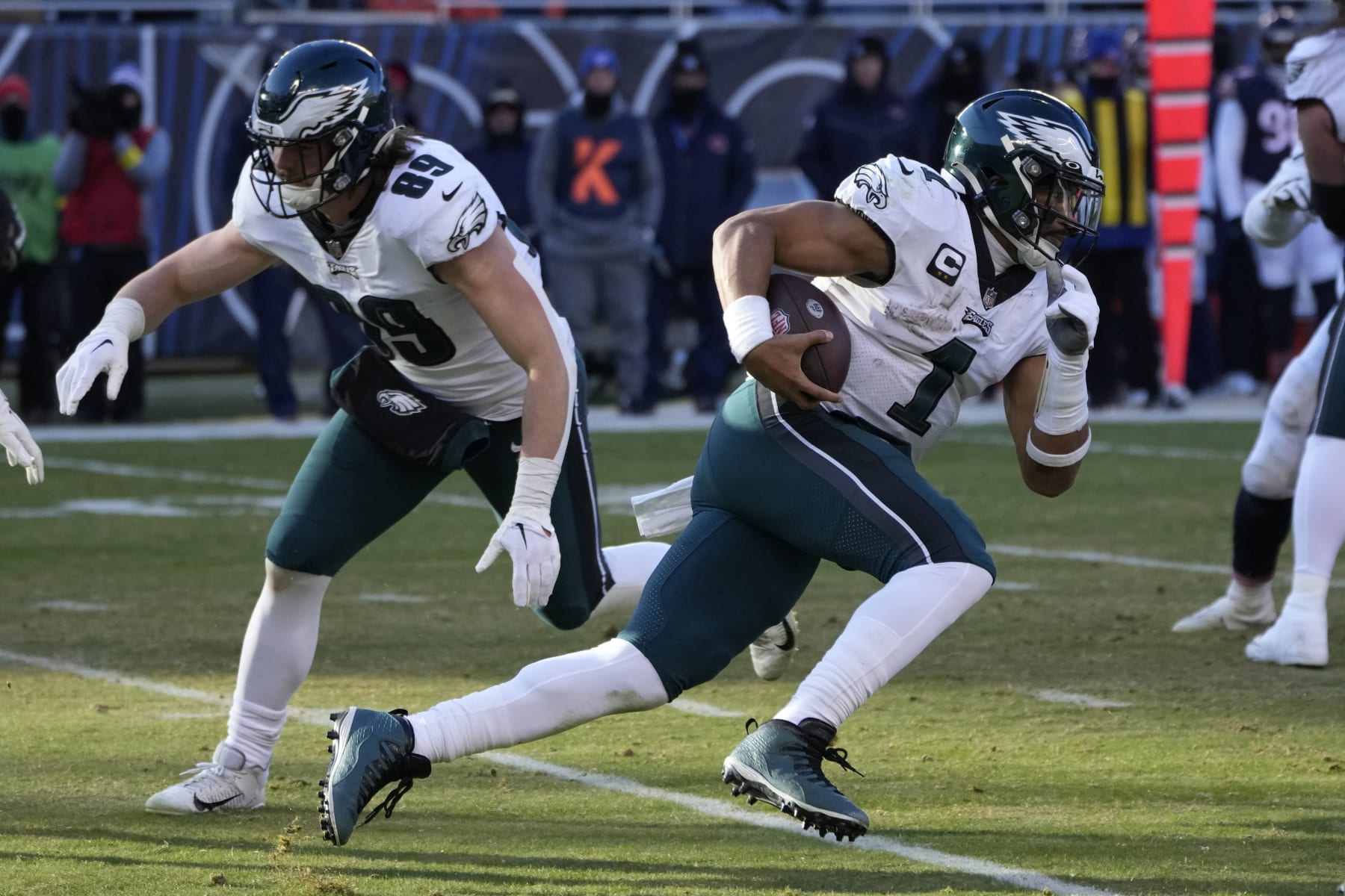 Philadelphia Eagles' Jalen Hurts carries the ball as tight end Jack Stoll protects his backside during an NFL football game against the Chicago Bears Sunday, Dec. 18, 2022, in Chicago. (AP Photo/Charles Rex Arbogast)