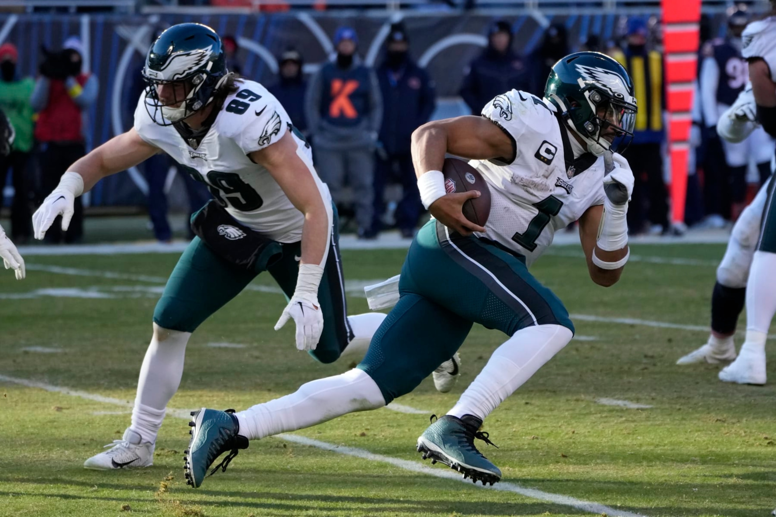 Philadelphia Eagles' Jalen Hurts carries the ball as tight end Jack Stoll protects his backside during an NFL football game against the Chicago Bears Sunday, Dec. 18, 2022, in Chicago. (AP Photo/Charles Rex Arbogast)