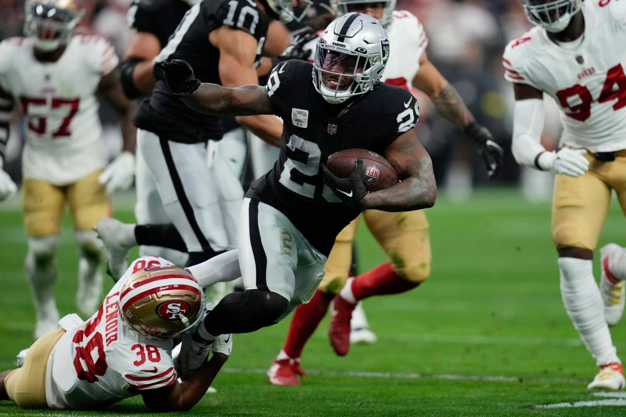 Las Vegas Raiders running back Josh Jacobs (28) is tackled by San Francisco 49ers cornerback Deommodore Lenoir (38) during the first half of an NFL football game between the San Francisco 49ers and Las Vegas Raiders, Sunday, Jan. 1, 2023, in Las Vegas. (AP Photo/John Locher)
