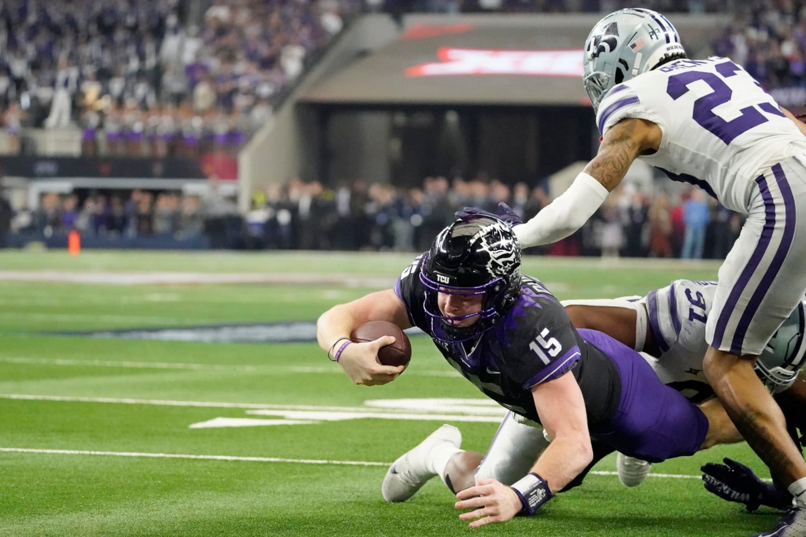 TCU quarterback Max Duggan (15) falls short of a touchdown as Kansas State defensive end Felix Anudike-Uzomah (91) and cornerback Julius Brents (23) make the stop during overtime of the Big 12 Conference championship NCAA college football game, Saturday, Dec. 3, 2022, in Arlington, Texas. (AP Photo/Mat Otero) TCU quarterback Max Duggan (15) falls short of a touchdown as Kansas State defensive end Felix Anudike-Uzomah (91) and cornerback Julius Brents (23) make the stop during overtime of the Big 12 Conference championship NCAA college football game, Saturday, Dec. 3, 2022, in Arlington, Texas. (AP Photo/Mat Otero)
