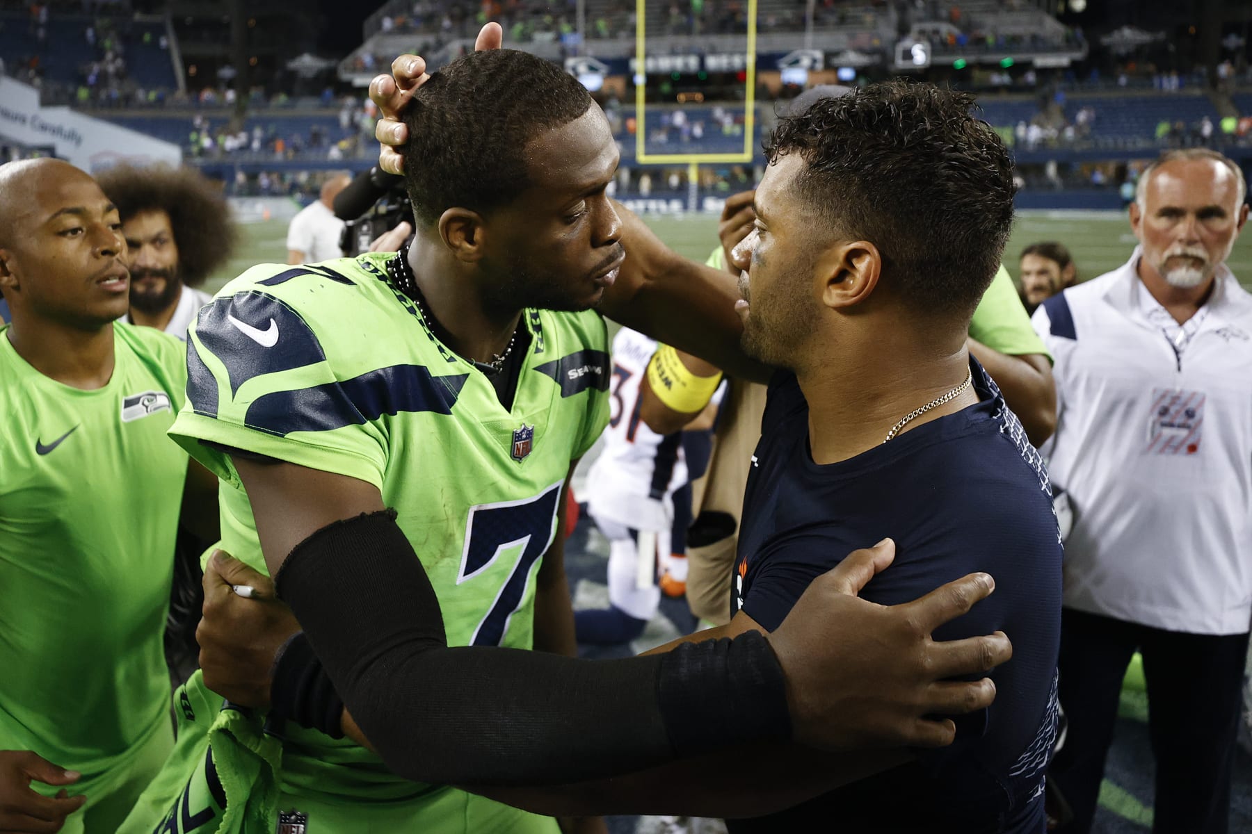 SEATTLE, WASHINGTON - SEPTEMBER 12: Geno Smith #7 of the Seattle Seahawks and Russell Wilson #3 of the Denver Broncos speak after the Seahawks defeated the Broncos 17-1 at Lumen Field on September 12, 2022 in Seattle, Washington. (Photo by Steph Chambers/Getty Images)