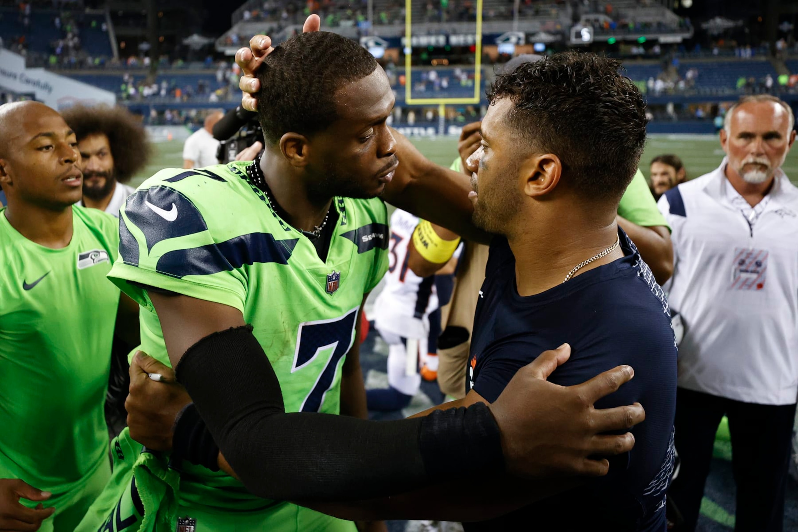 SEATTLE, WASHINGTON - SEPTEMBER 12: Geno Smith #7 of the Seattle Seahawks and Russell Wilson #3 of the Denver Broncos speak after the Seahawks defeated the Broncos 17-1 at Lumen Field on September 12, 2022 in Seattle, Washington. (Photo by Steph Chambers/Getty Images)