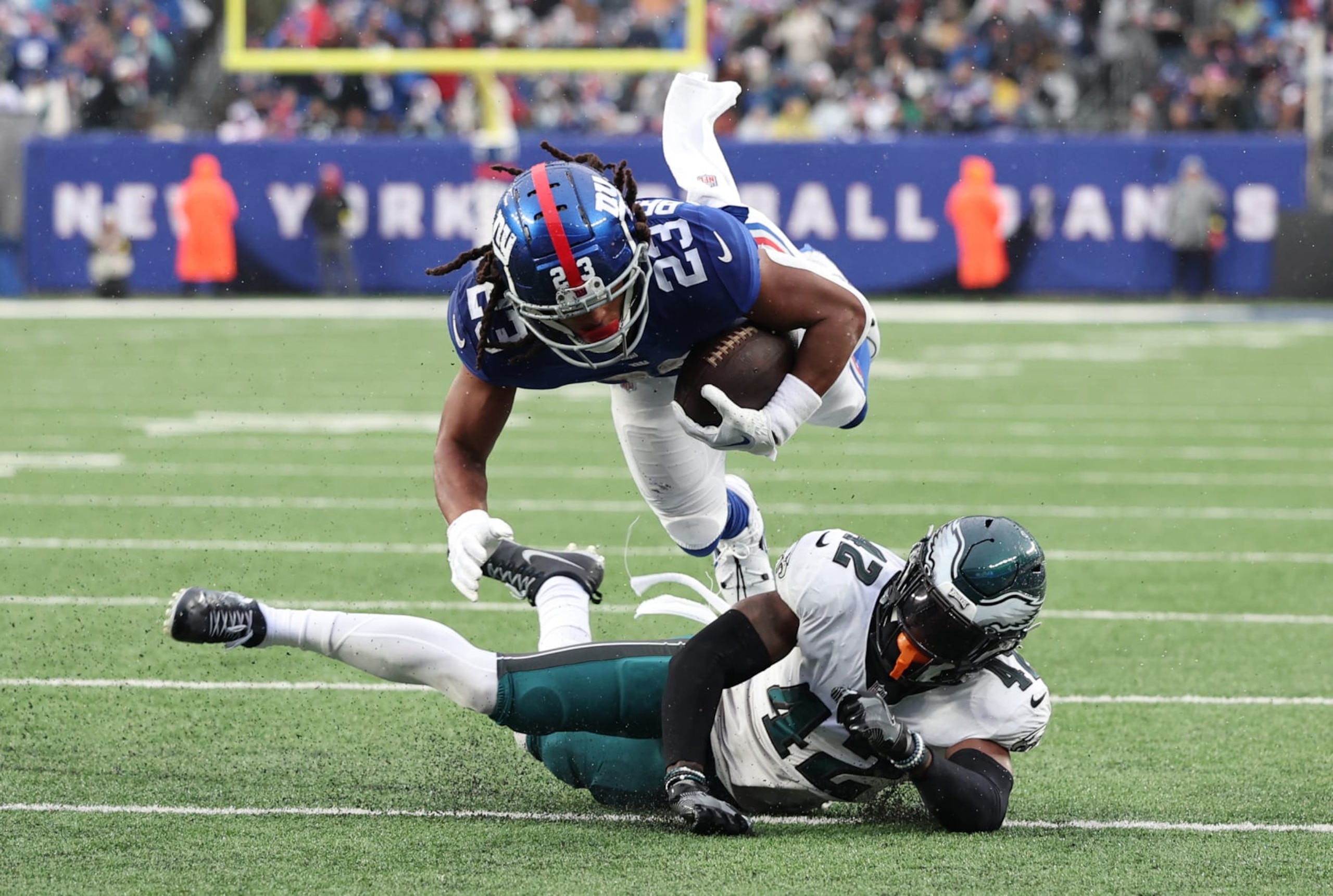 Giants RB Gary Brightwell jumps over K'Von Wallace. 