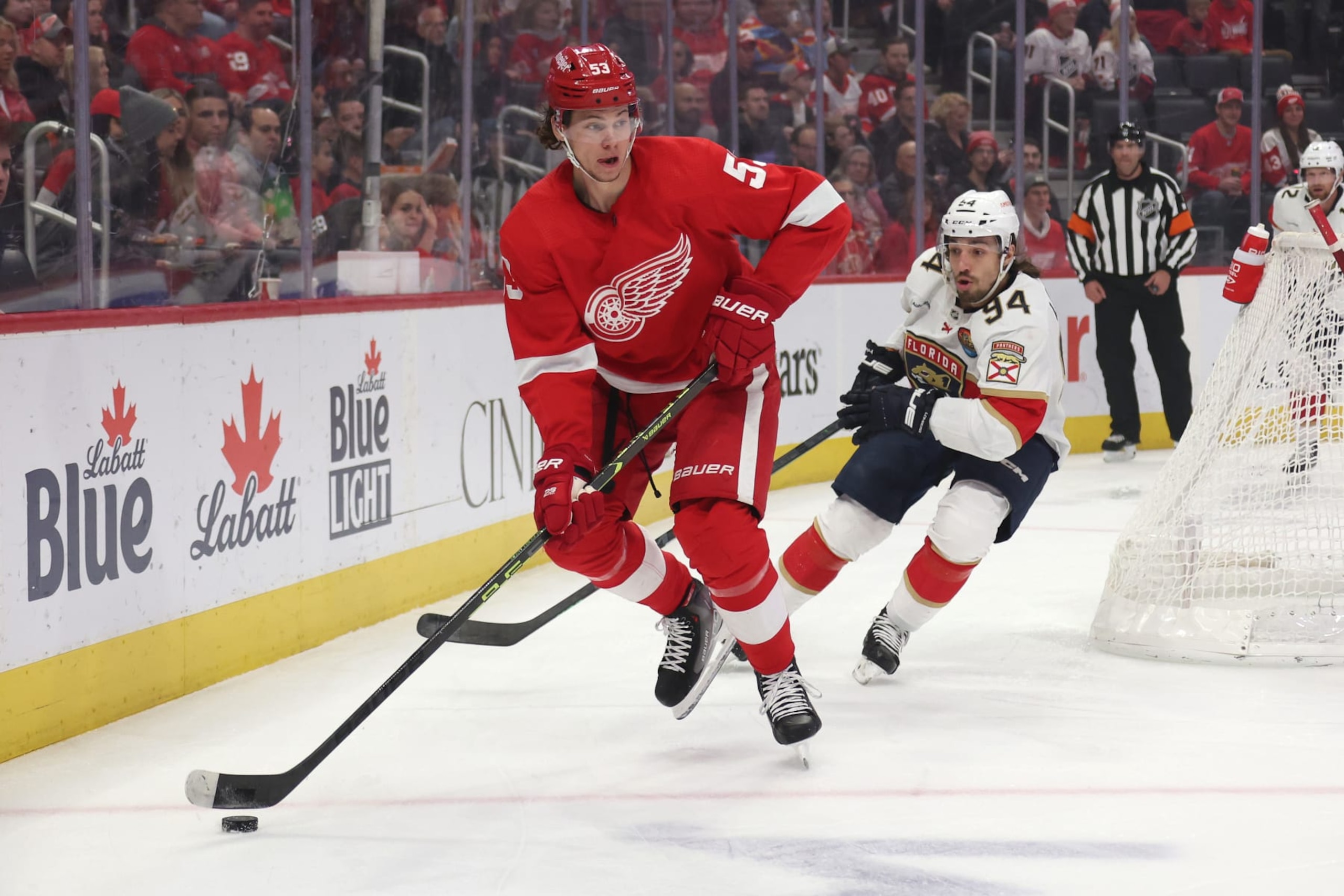 DETROIT, MICHIGAN - JANUARY 06: Moritz Seider #53 of the Detroit Red Wings looks to pass in front of Ryan Lomberg #94 of the Florida Panthers during the first period at Little Caesars Arena on January 06, 2023 in Detroit, Michigan. (Photo by Gregory Shamus/Getty Images)