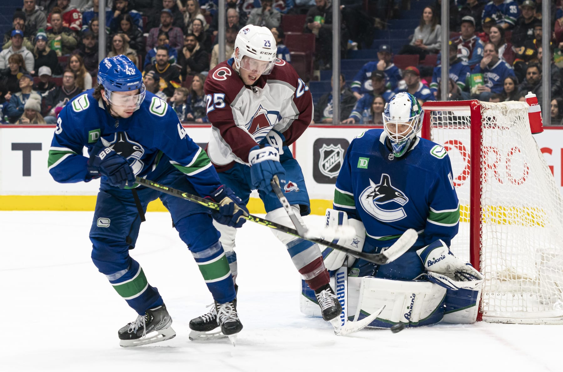 VANCOUVER, CANADA - JANUARY 5:  Logan O'Connor #25 of the Colorado Avalanche tries to tip the puck on goalie Collin Delia #60 of the Vancouver Canucks while battling with Quinn Hughes #43 of the Vancouver Canucks NHL action on January, 5, 2023 at Rogers Arena in Vancouver, British Columbia, Canada.  (Photo by Rich Lam/Getty Images)