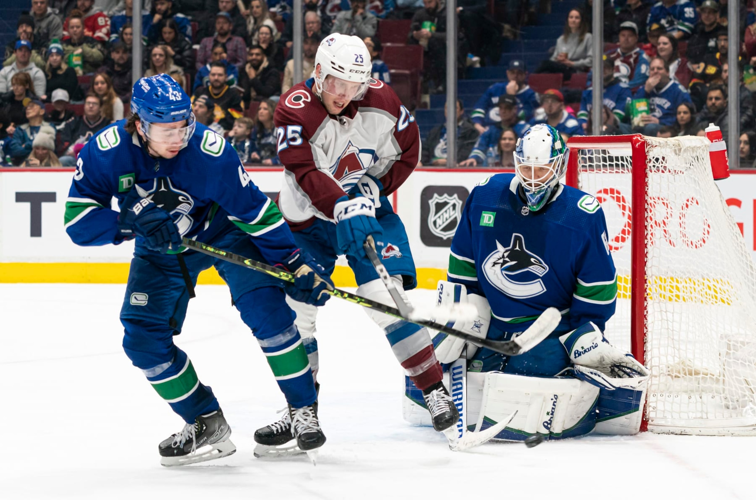 VANCOUVER, CANADA - JANUARY 5:  Logan O'Connor #25 of the Colorado Avalanche tries to tip the puck on goalie Collin Delia #60 of the Vancouver Canucks while battling with Quinn Hughes #43 of the Vancouver Canucks NHL action on January, 5, 2023 at Rogers Arena in Vancouver, British Columbia, Canada.  (Photo by Rich Lam/Getty Images)