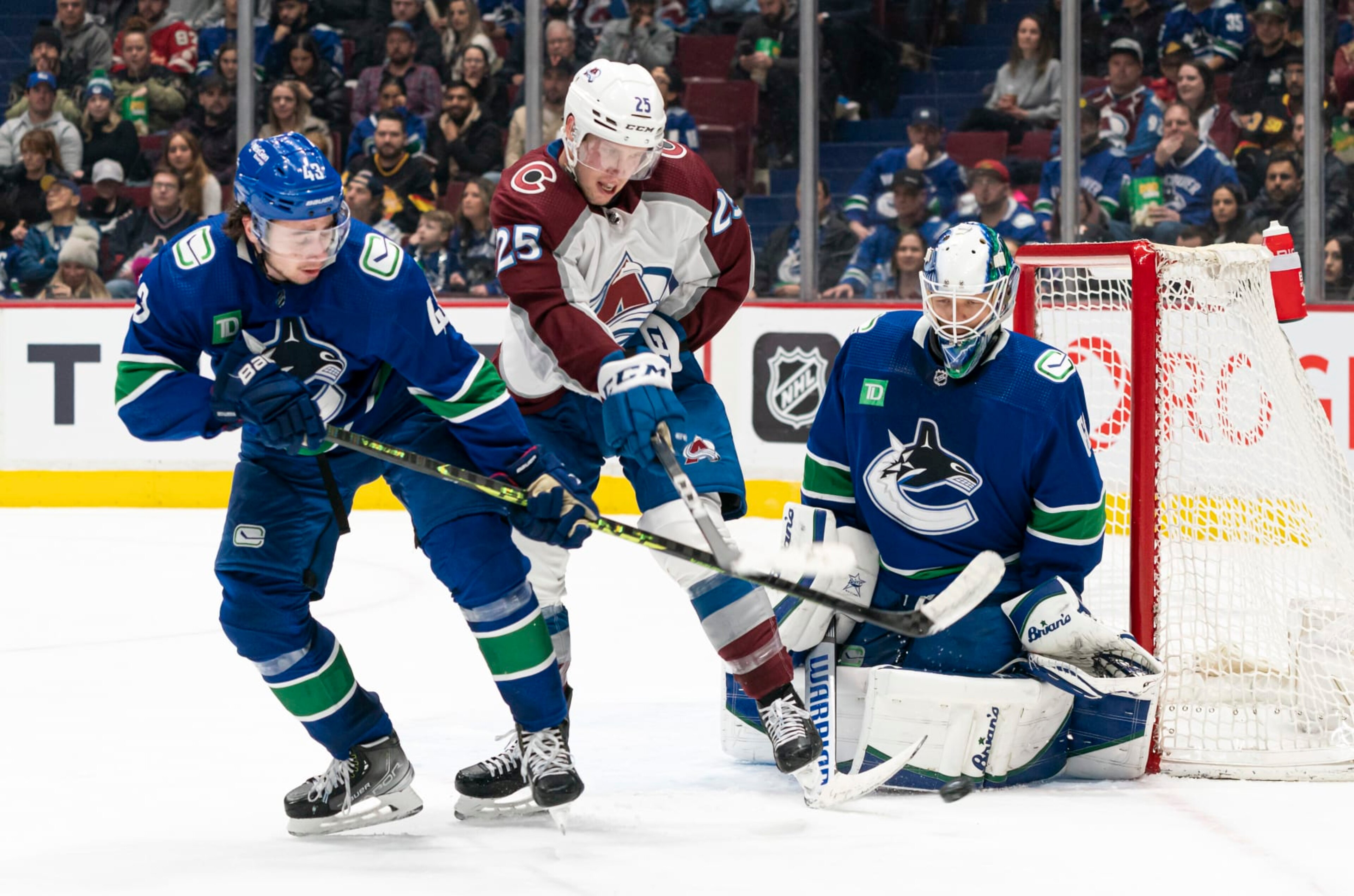 VANCOUVER, CANADA - JANUARY 5:  Logan O'Connor #25 of the Colorado Avalanche tries to tip the puck on goalie Collin Delia #60 of the Vancouver Canucks while battling with Quinn Hughes #43 of the Vancouver Canucks NHL action on January, 5, 2023 at Rogers Arena in Vancouver, British Columbia, Canada.  (Photo by Rich Lam/Getty Images)