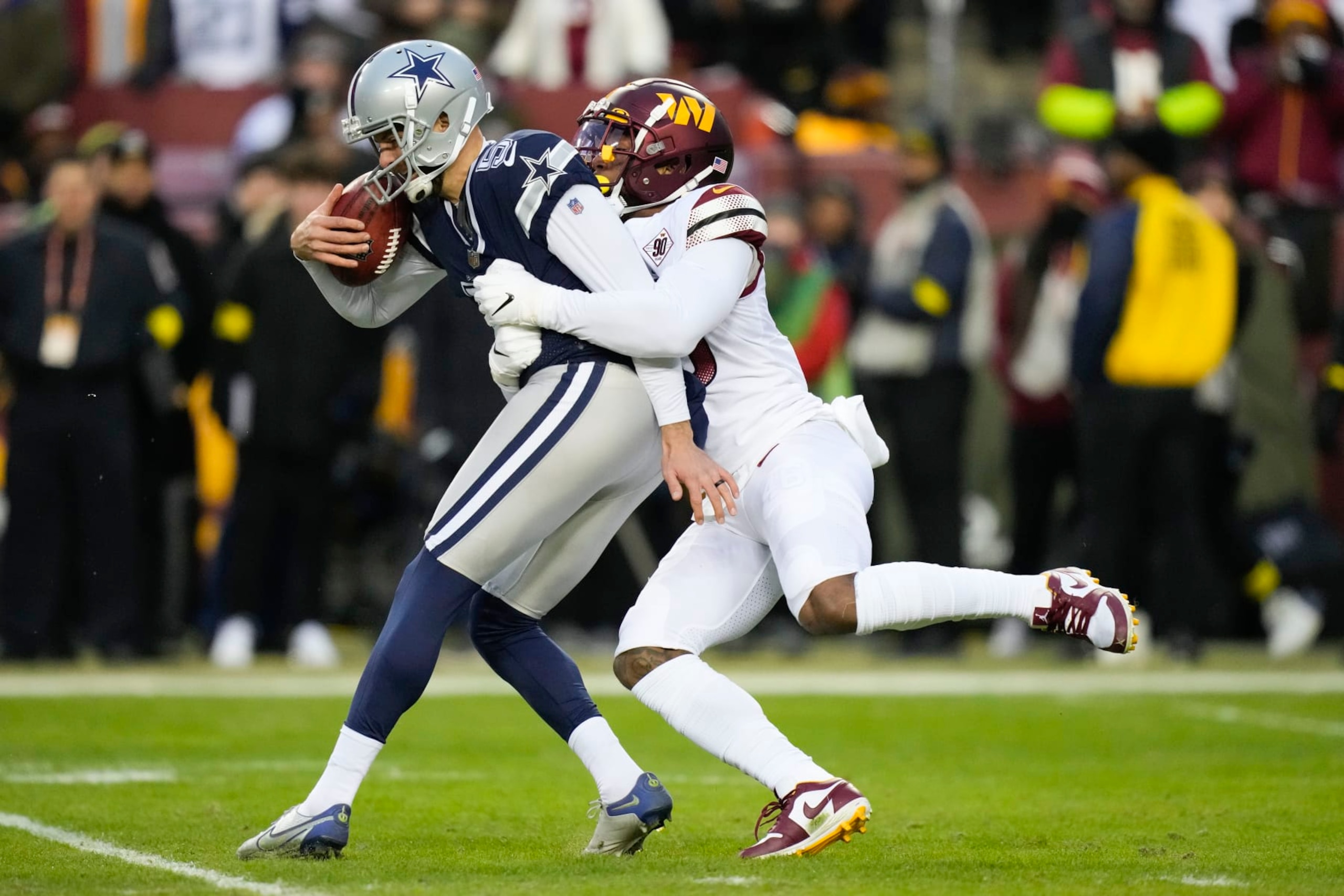 Washington Commanders linebacker Milo Eifler (46) tackles Dallas Cowboys punter Bryan Anger (5) during the first half an NFL football game, Sunday, Jan. 8, 2023, in Landover, Md. (AP Photo/Alex Brandon)