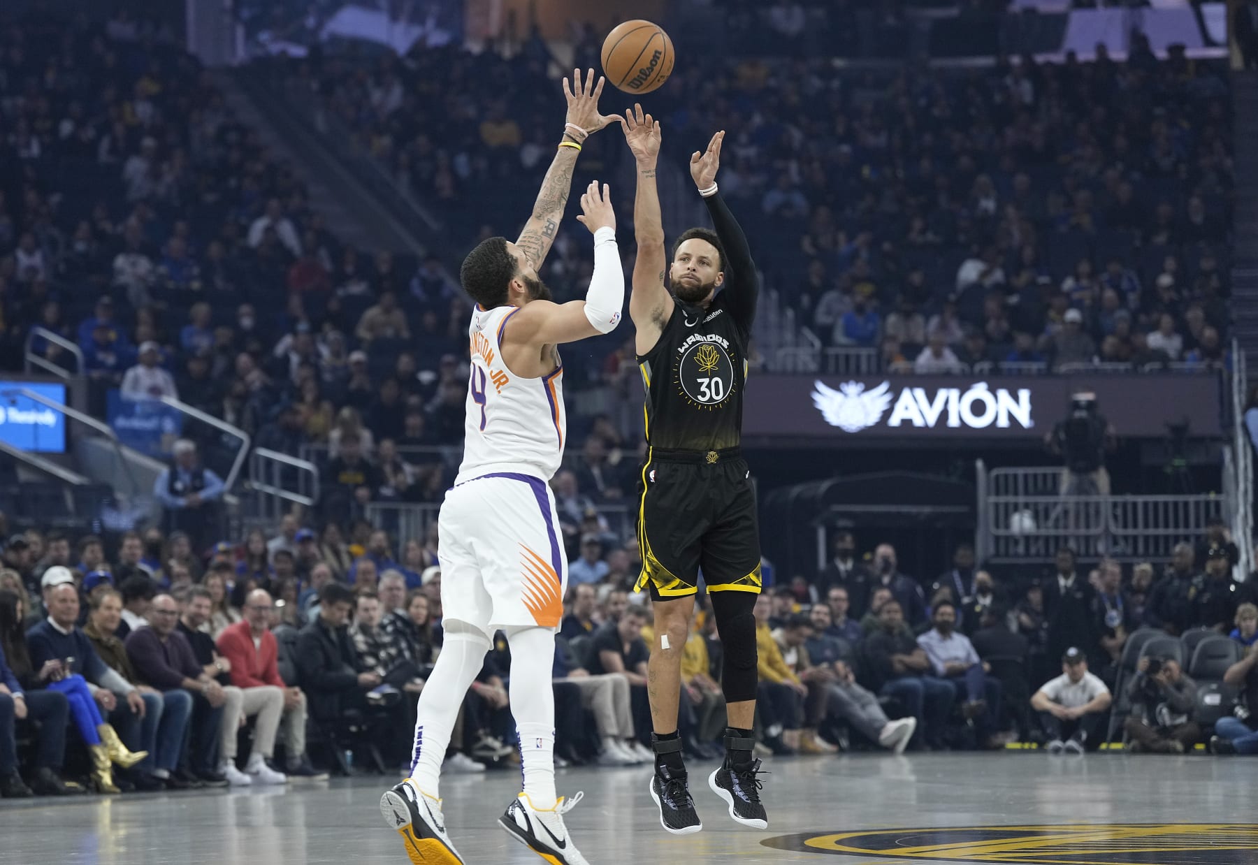 SAN FRANCISCO, CALIFORNIA - JANUARY 10: Stephen Curry #30 of the Golden State Warriors shoots a three-point shot over Duane Washington Jr. #4 of the Phoenix Suns during the first quarter at Chase Center on January 10, 2023 in San Francisco, California. NOTE TO USER: User expressly acknowledges and agrees that, by downloading and or using this photograph, User is consenting to the terms and conditions of the Getty Images License Agreement. (Photo by Thearon W. Henderson/Getty Images)