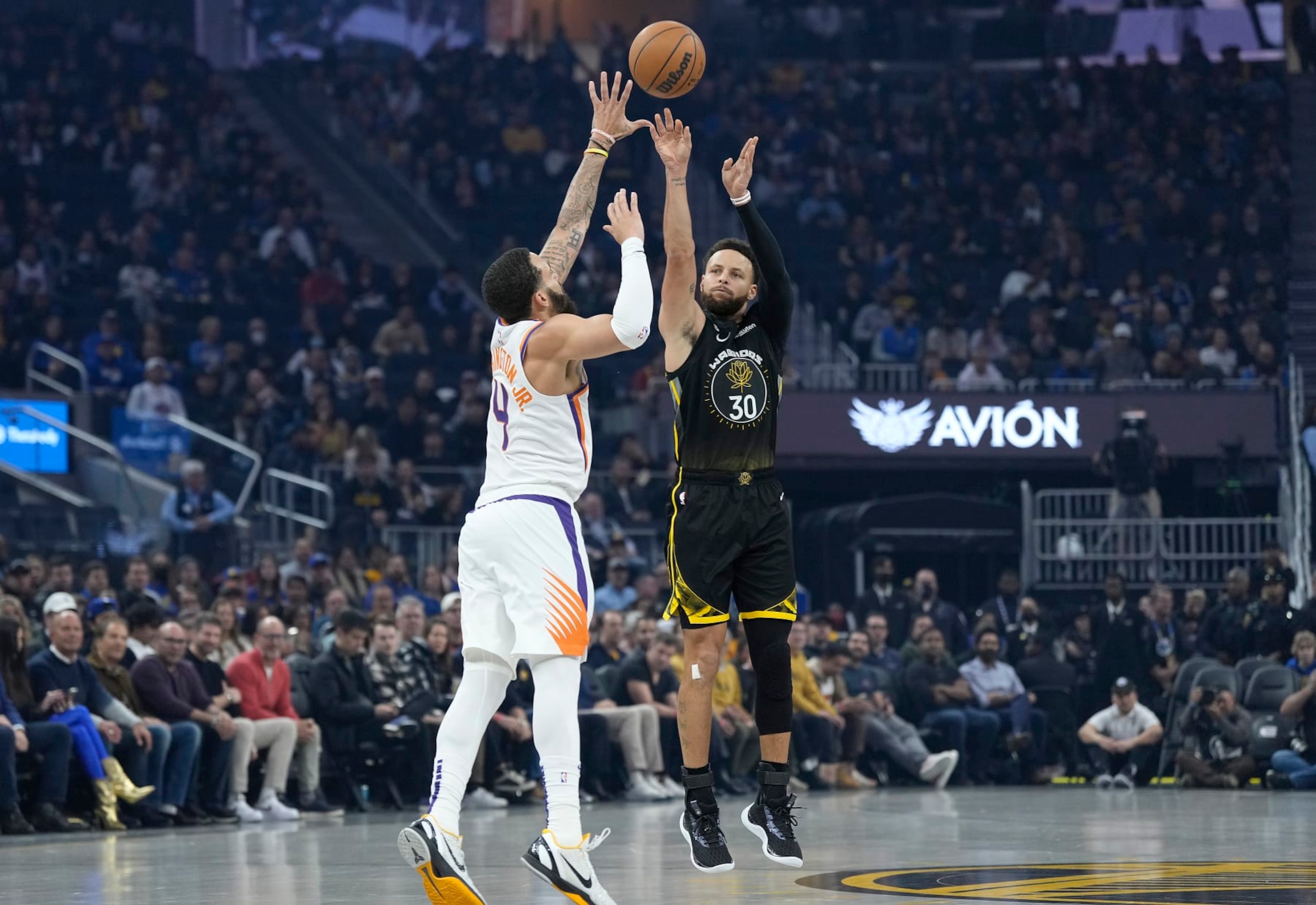 SAN FRANCISCO, CALIFORNIA - JANUARY 10: Stephen Curry #30 of the Golden State Warriors shoots a three-point shot over Duane Washington Jr. #4 of the Phoenix Suns during the first quarter at Chase Center on January 10, 2023 in San Francisco, California. NOTE TO USER: User expressly acknowledges and agrees that, by downloading and or using this photograph, User is consenting to the terms and conditions of the Getty Images License Agreement. (Photo by Thearon W. Henderson/Getty Images)