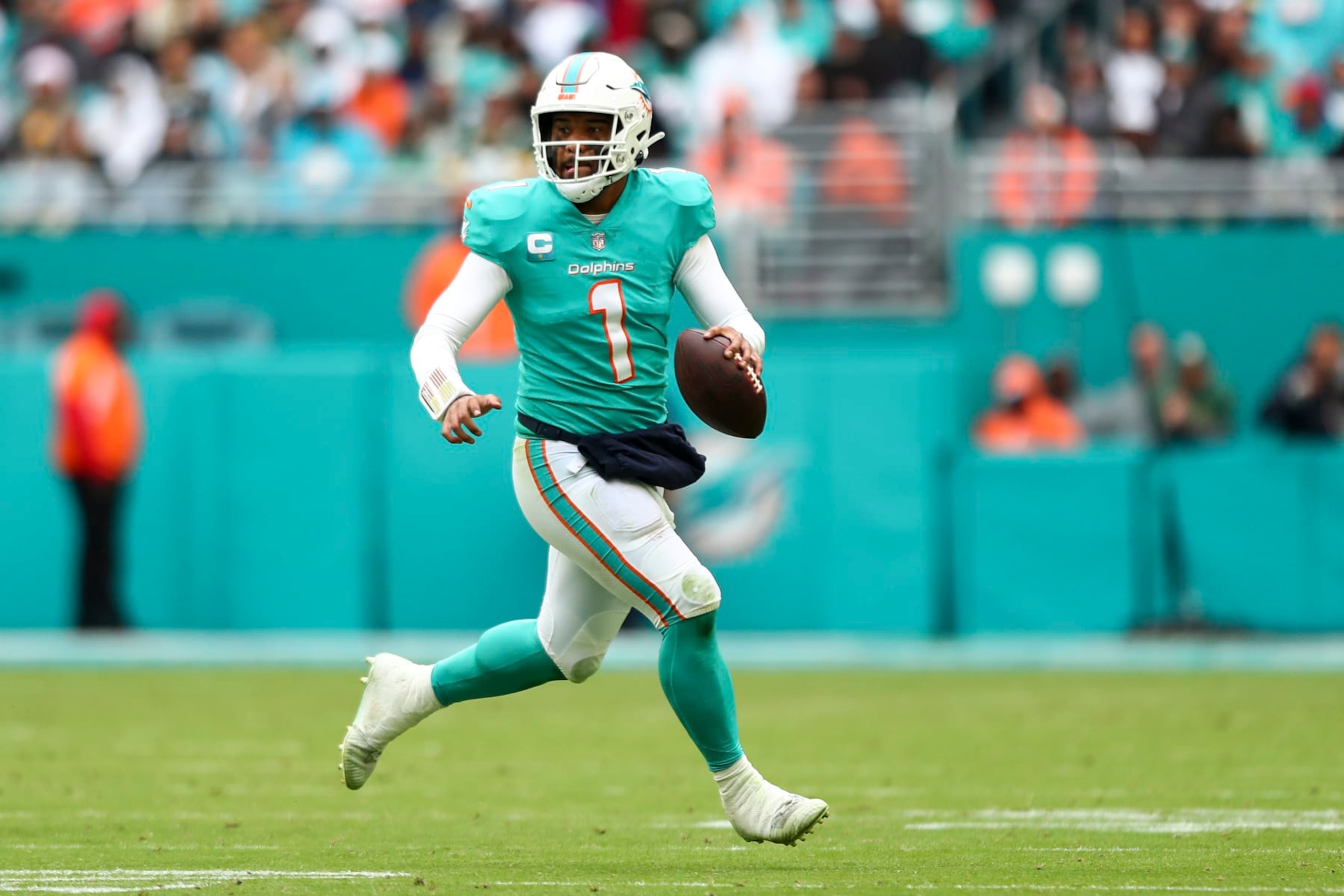MIAMI GARDENS, FL - DECEMBER 25: Tua Tagovailoa #1 of the Miami Dolphins scrambles out of the pocket during the third quarter of an NFL football game against the Green Bay Packers at Hard Rock Stadium on December 25, 2022 in Miami Gardens, Florida. (Photo by Kevin Sabitus/Getty Images)