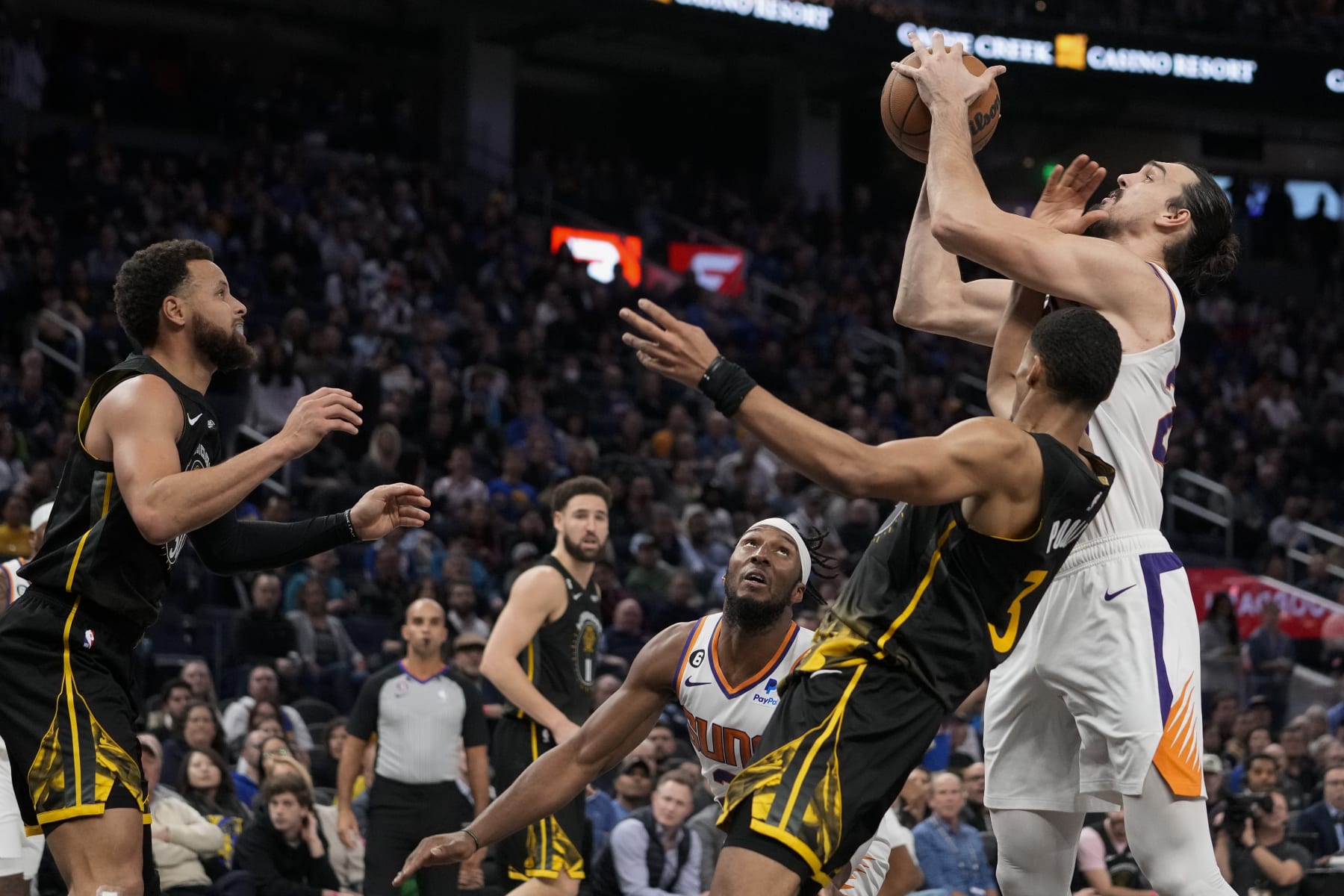 Phoenix Suns forward Dario Saric, right, and Golden State Warriors guard Jordan Poole (3) compete for possession of the ball during the second half of an NBA basketball game in San Francisco, Tuesday, Jan. 10, 2023. (AP Photo/Godofredo A. Vásquez)