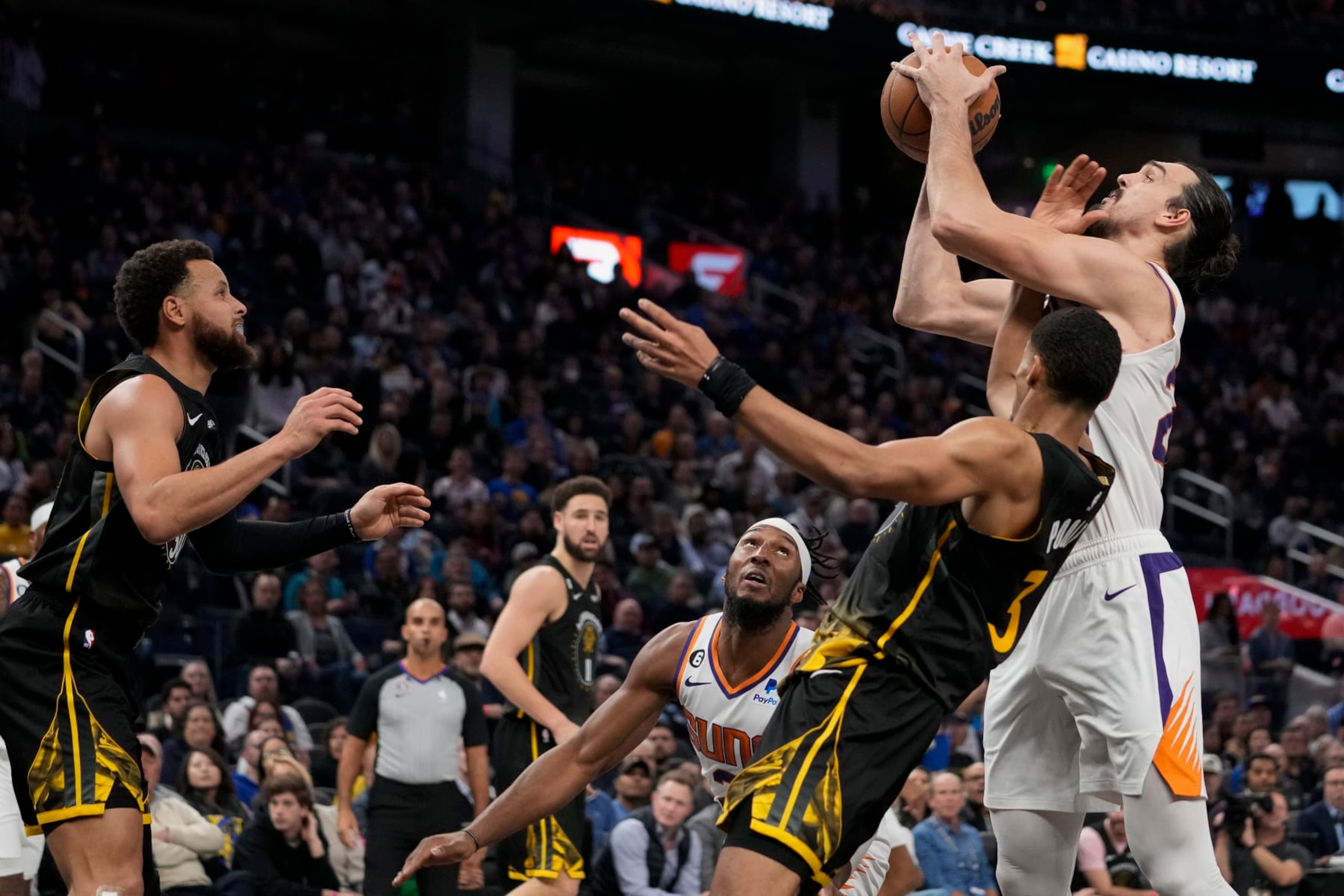 Phoenix Suns forward Dario Saric, right, and Golden State Warriors guard Jordan Poole (3) compete for possession of the ball during the second half of an NBA basketball game in San Francisco, Tuesday, Jan. 10, 2023. (AP Photo/Godofredo A. Vásquez)